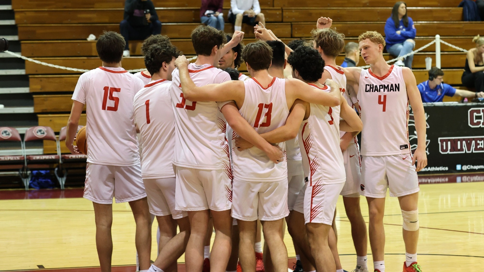 The men's basketball team huddles during a timeout.