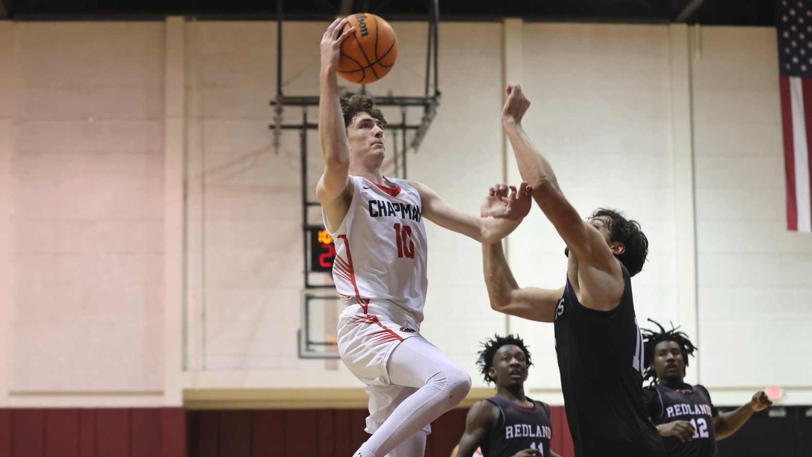 Joe Keegan jumps over a defender to shoot a layup.
