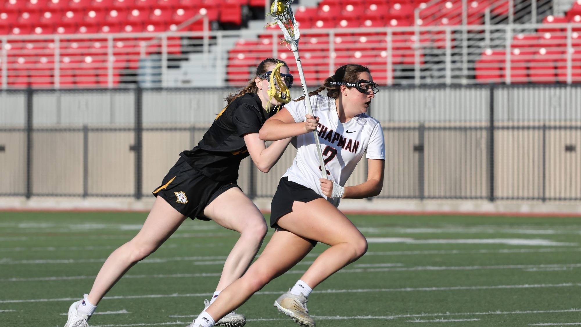 Madi Escobar runs past a defender playing lacrosse.