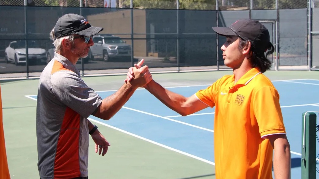 Evan Parry congratulates a player after his tennis match.