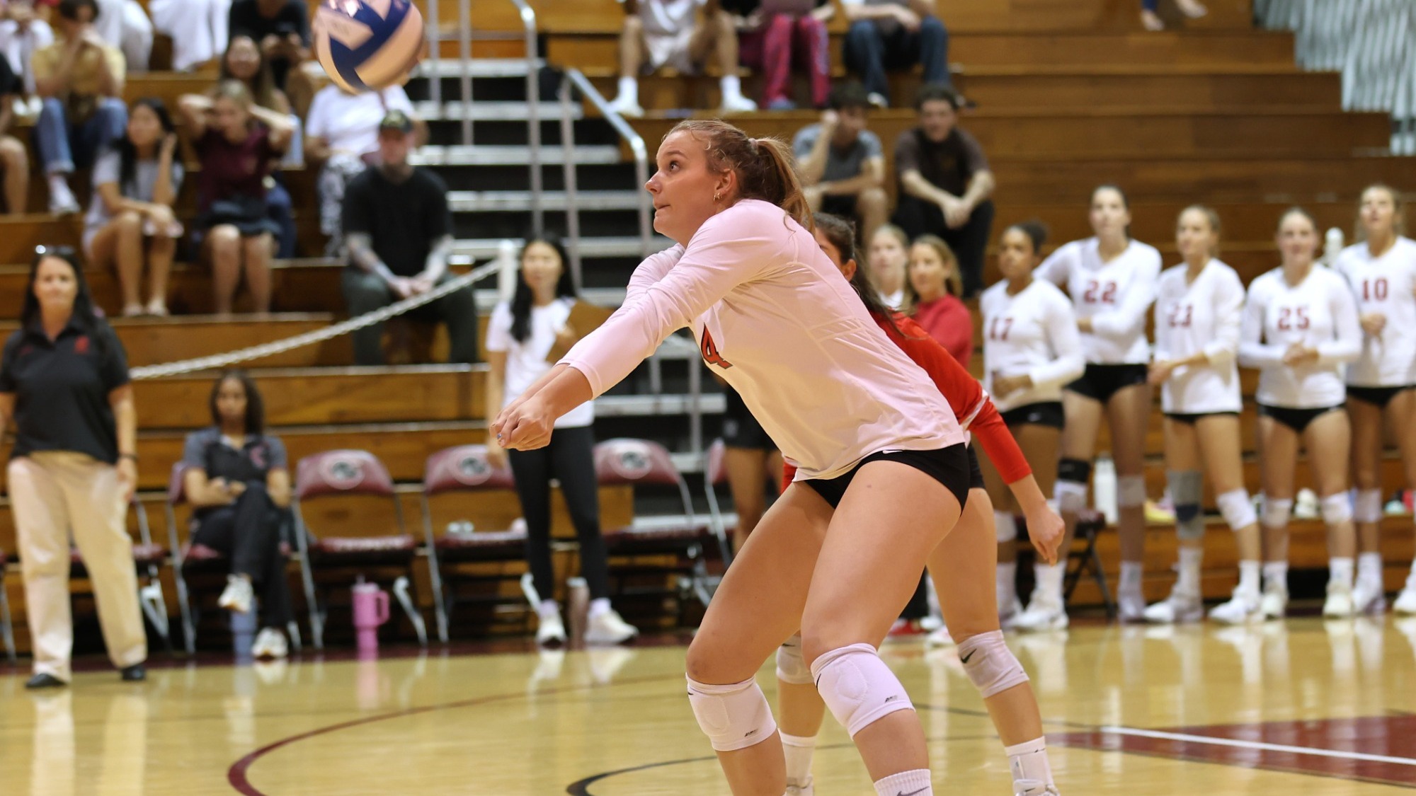 Kaya Jedrzejczak with her arms out on the volleyball court with the ball coming at her.