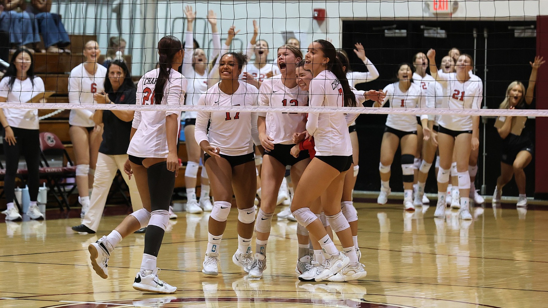 The volleyball team celebrates scoring a point.