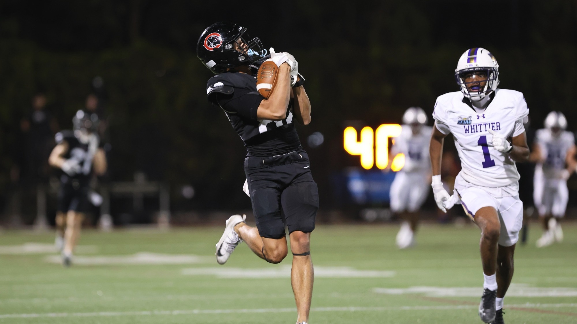 A Chapman player catches a pass on the football field.