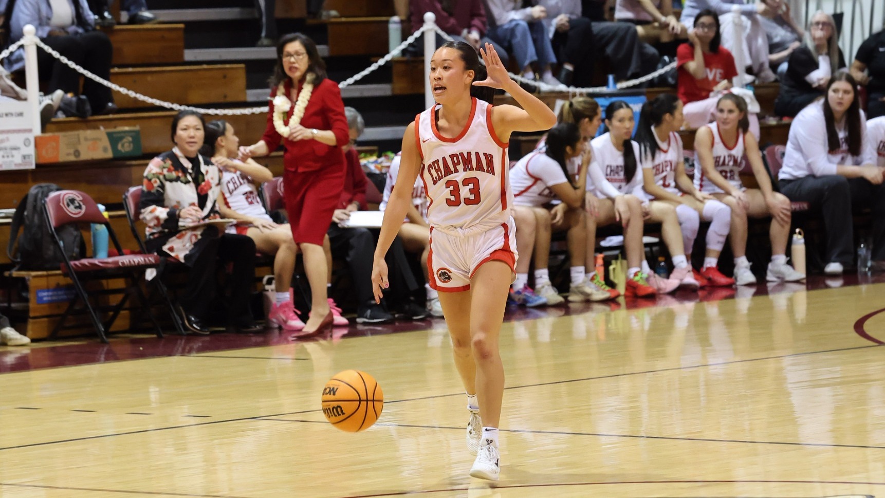 Makena Nitao dribbles the ball at midcourt.