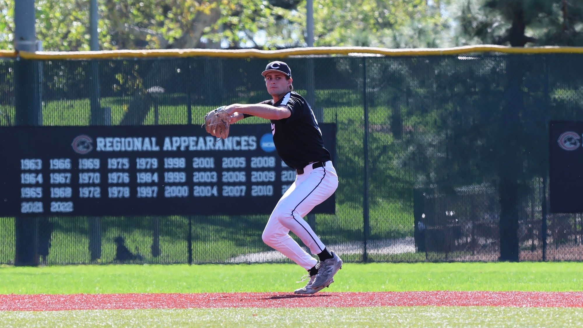 Joey Capobianco throws the ball to first base on the baseball field.