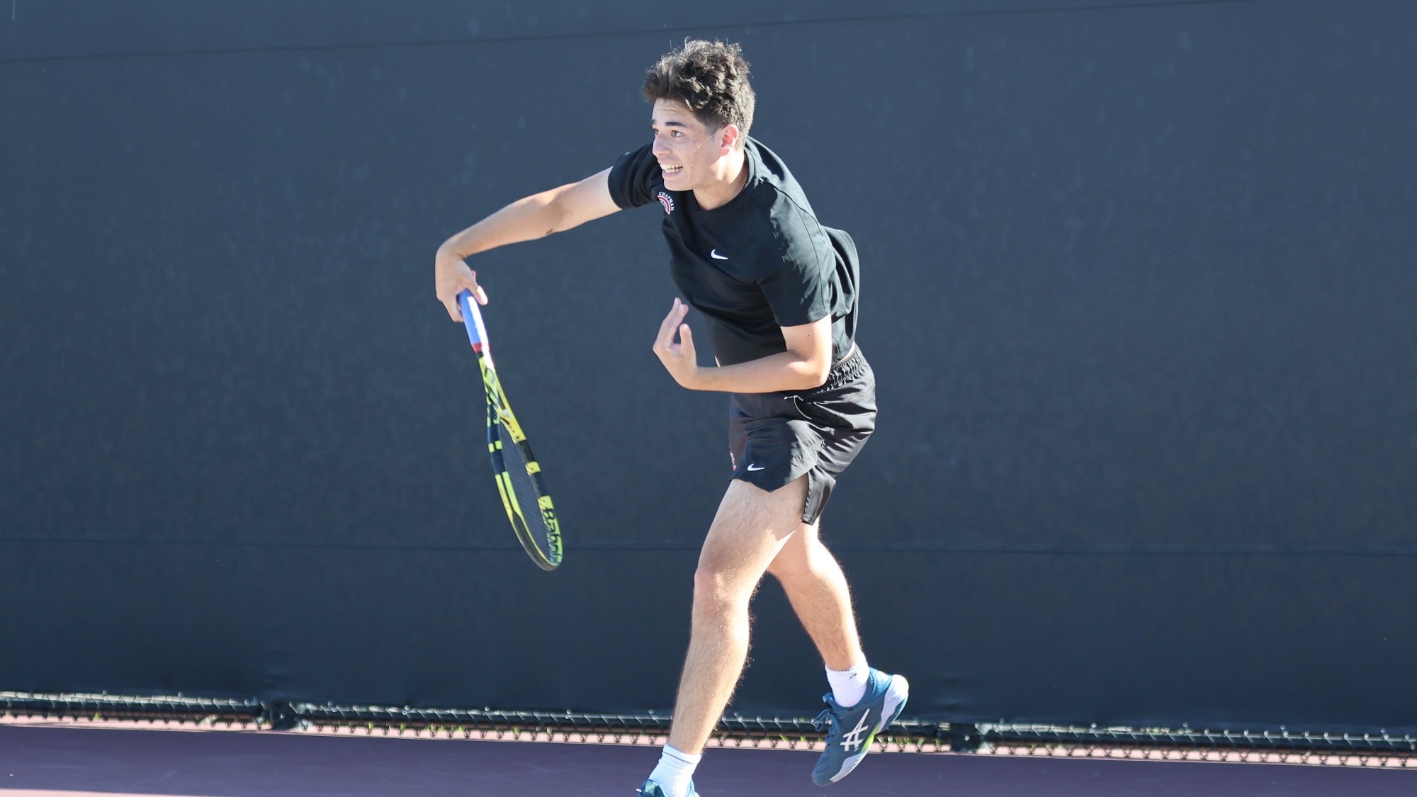 James Krantz after a serve on the tennis court.