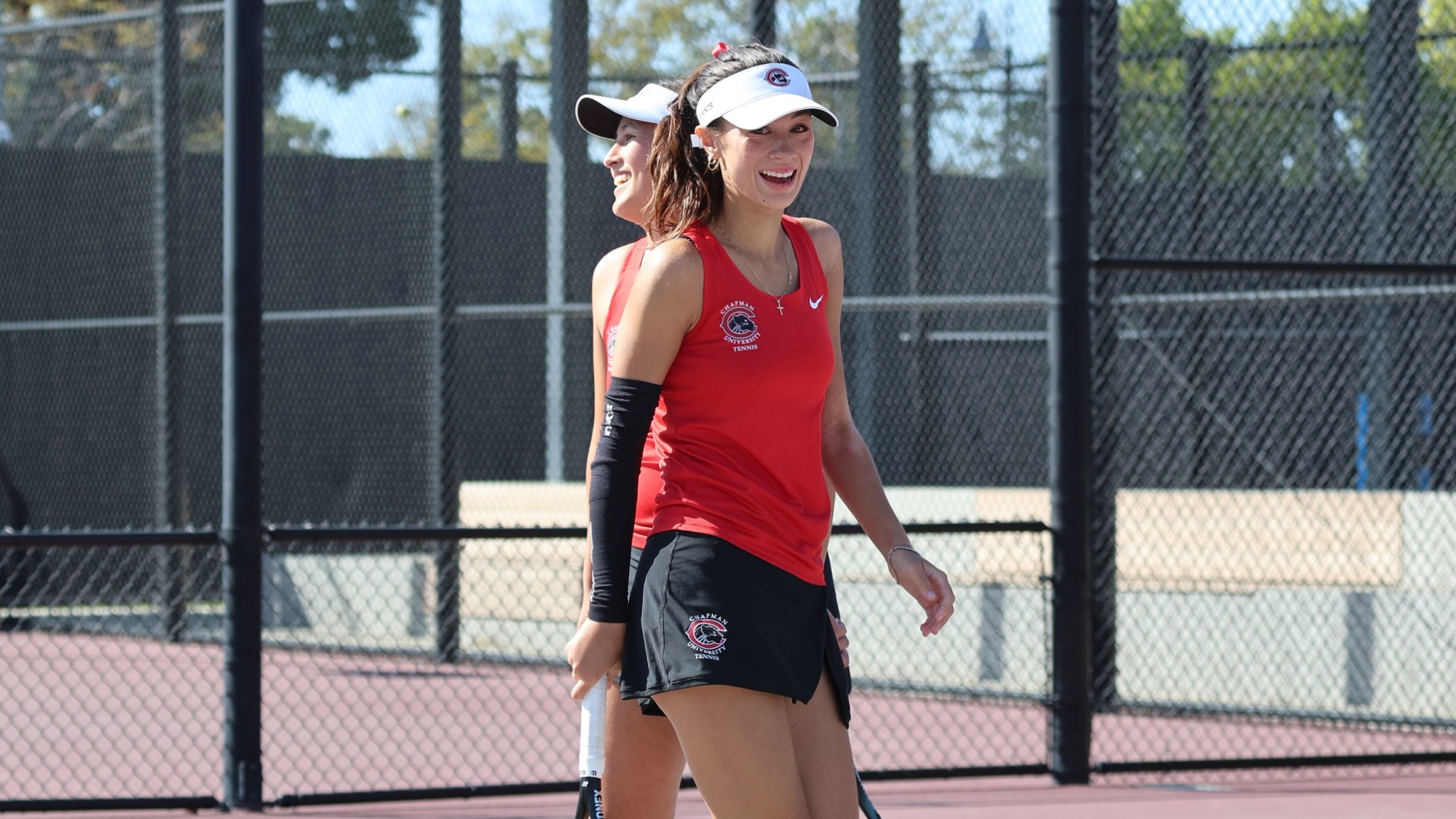 Makaylee and Malina Dahms smile after winning a doubles point.