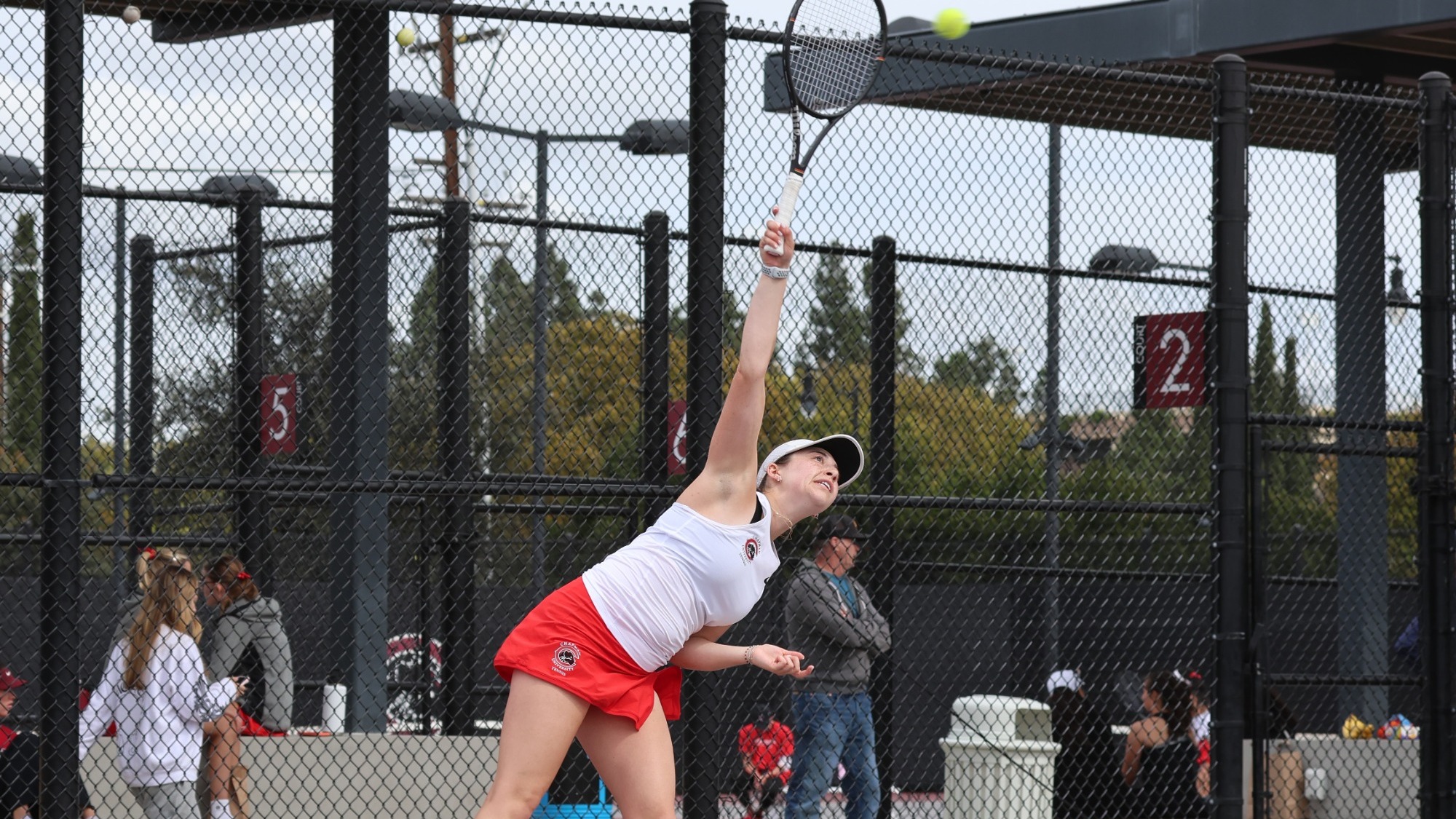 Lucy Wallin serves in a tennis match.