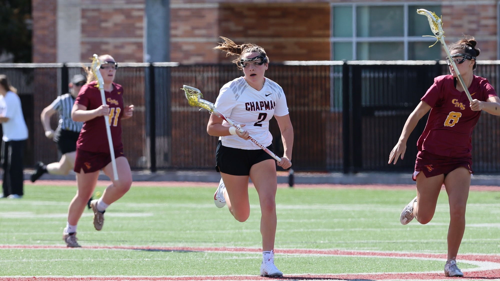 Madi Escobar on the lacrosse field running past defenders.