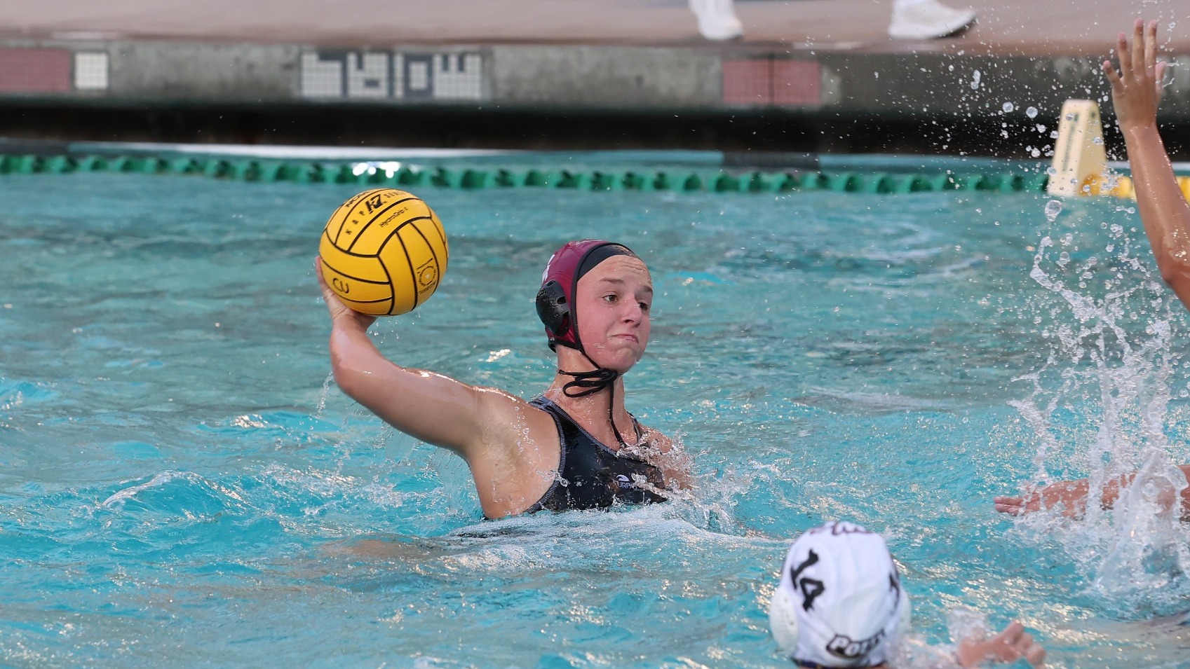 Mia Harrison in the pool taking a shot with a water polo ball.