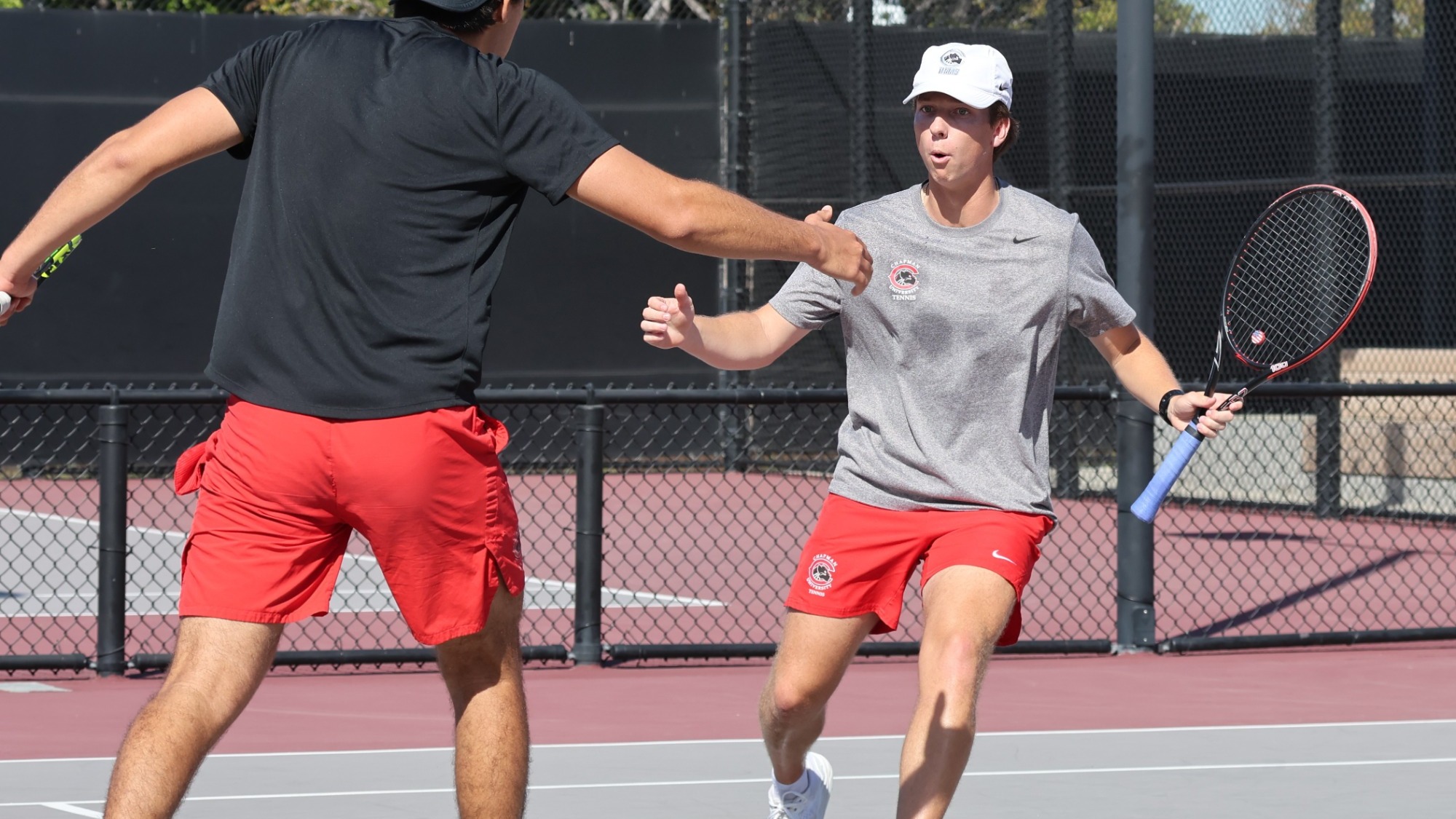 Aram Izmirian high-fives his doubles partner.