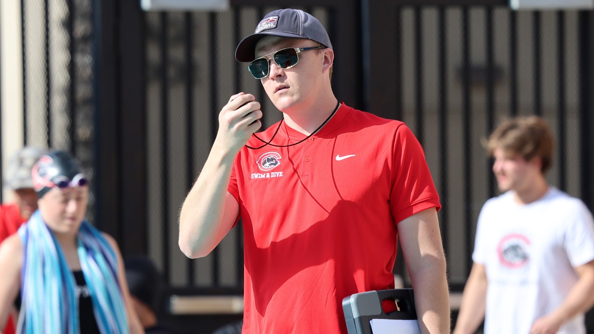 Jason Willman holds a stopwatch during a swimming race.