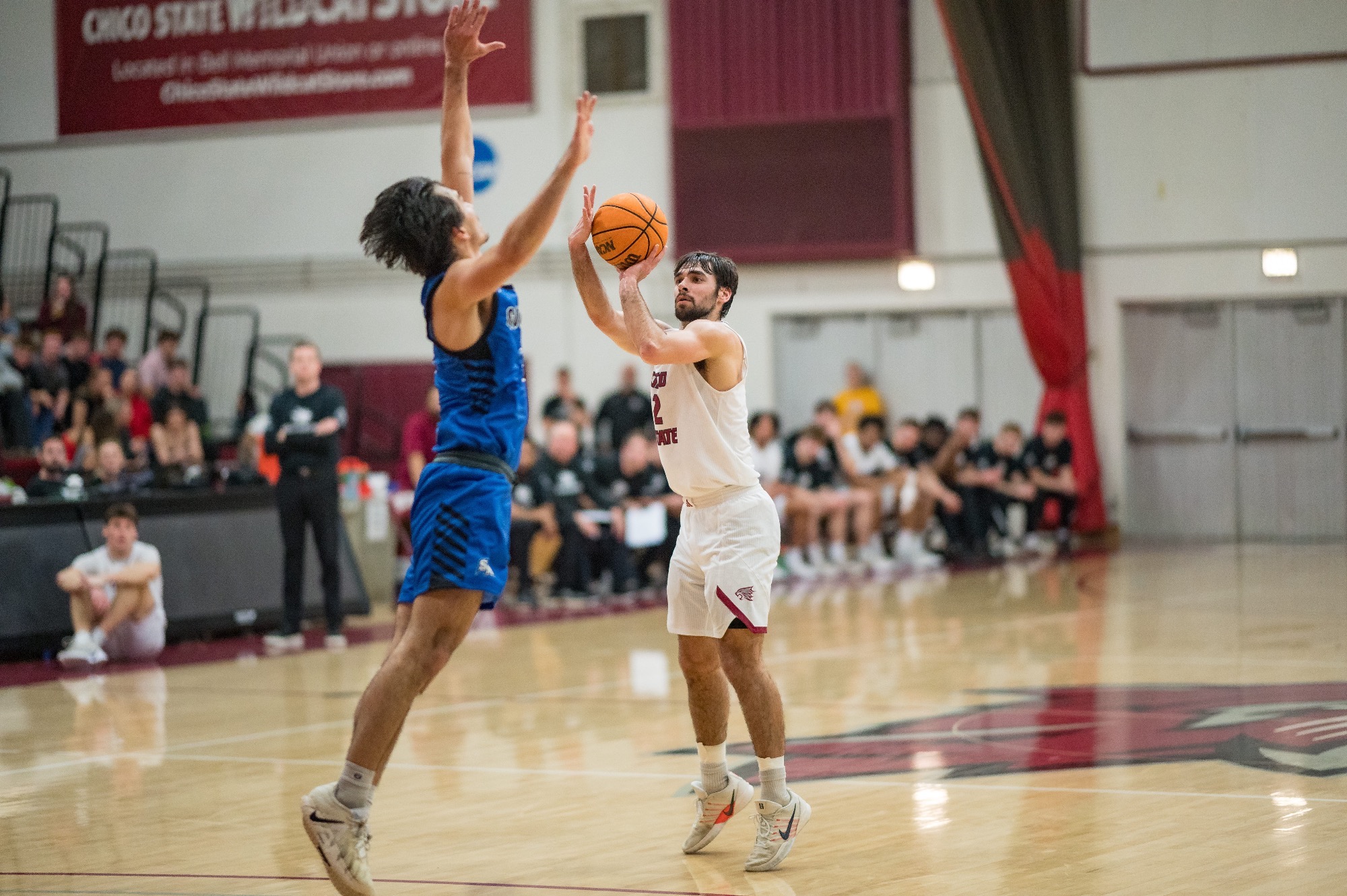 Ned Joyce shooting three pointer over a Cougars defender flying in to block his shot