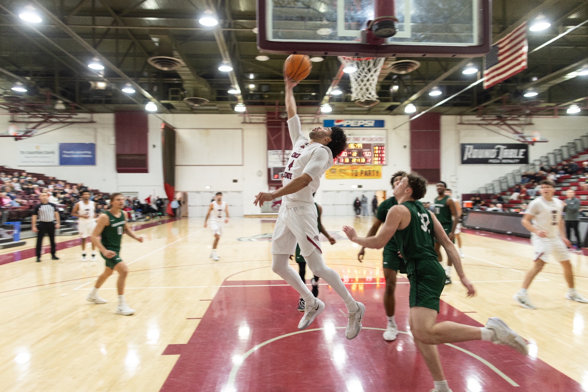 Chris Holley #4 lays up the ball in a reverse layup against Cal Poly Humboldt