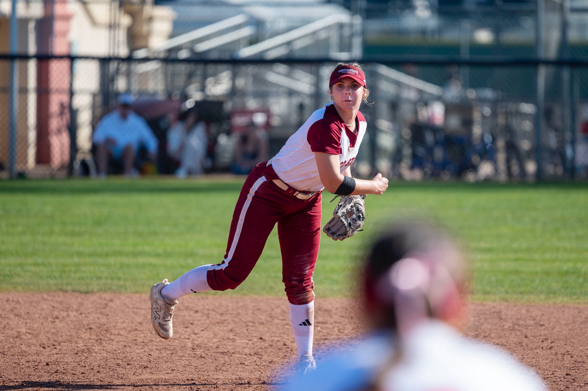 Lucy Sherburne throwing the ball from shortstop to first base 