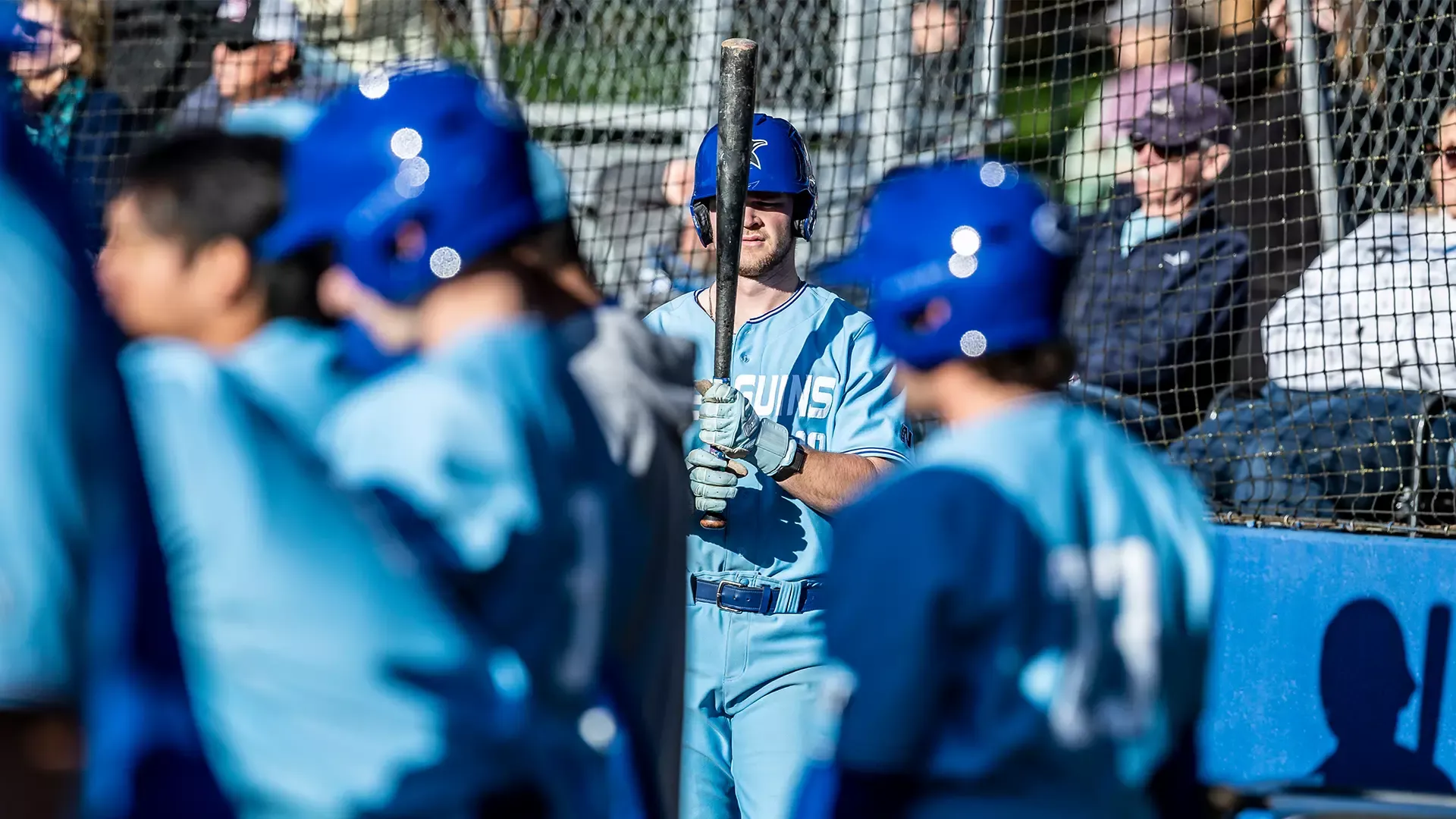 Reece Fisher prepping his bat in the dugout