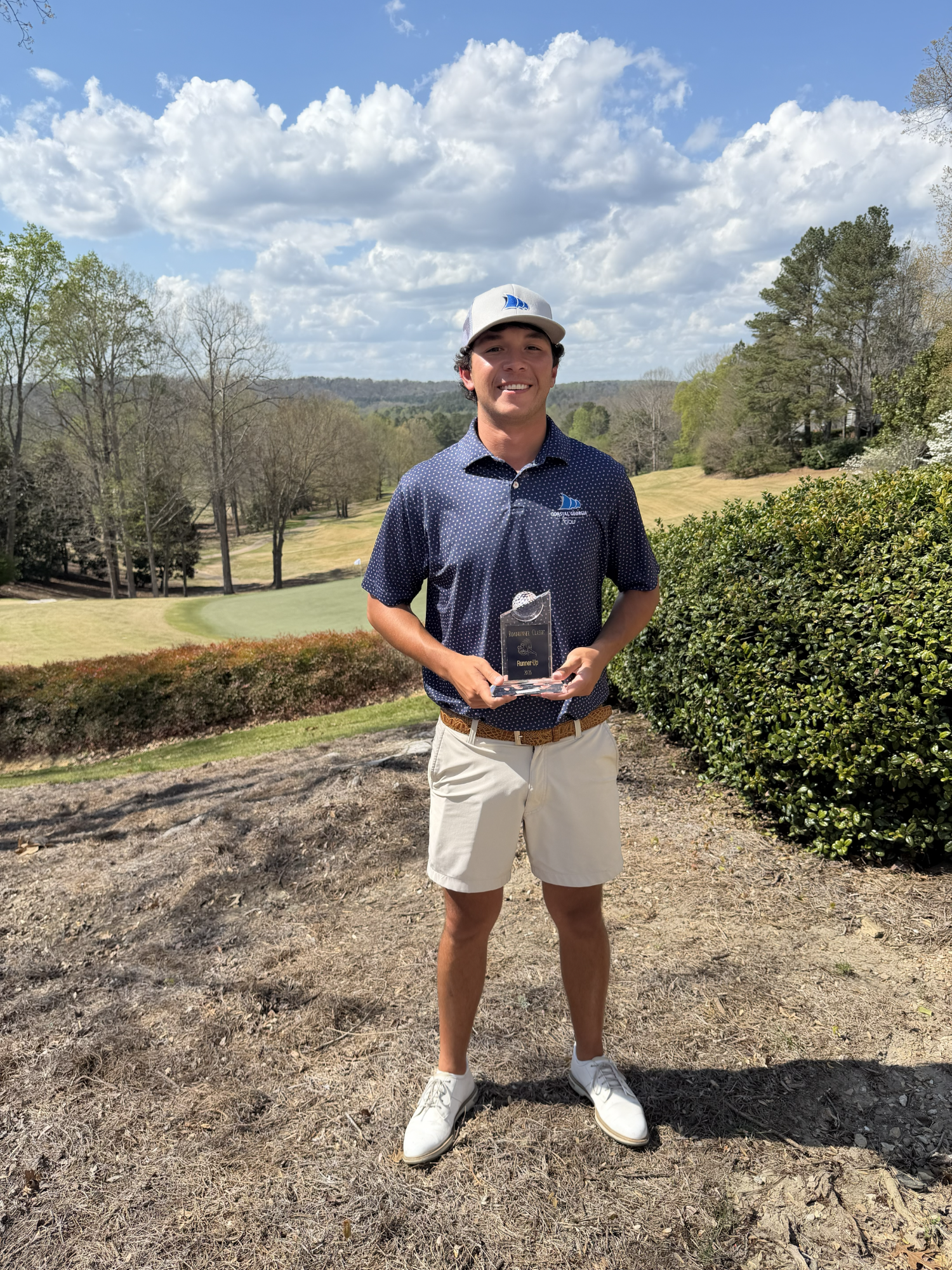 A CCGA golf player holds his runner up trophy