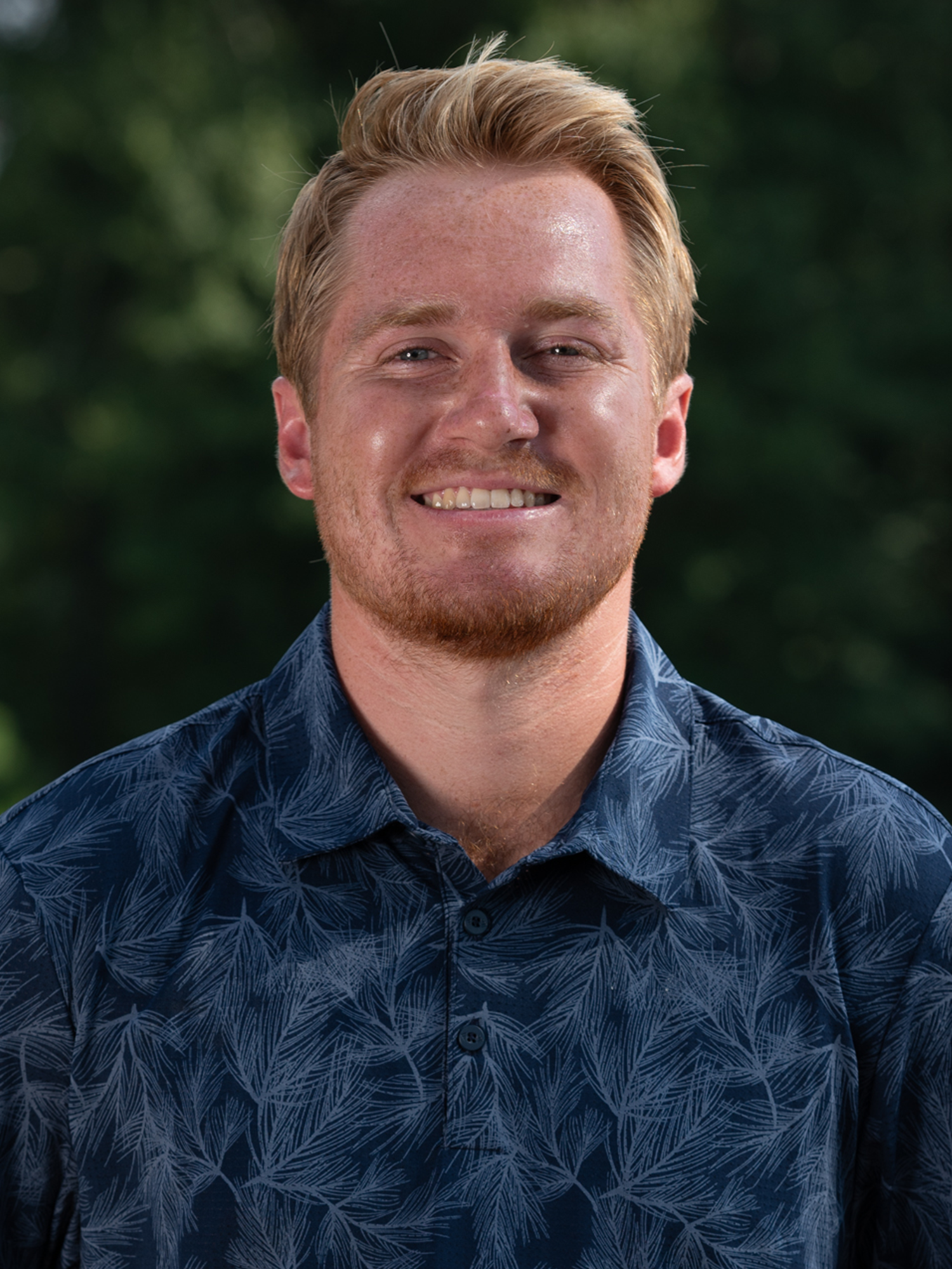 Head Men's Golf Coach Jake Montgomery poses for his headshot 