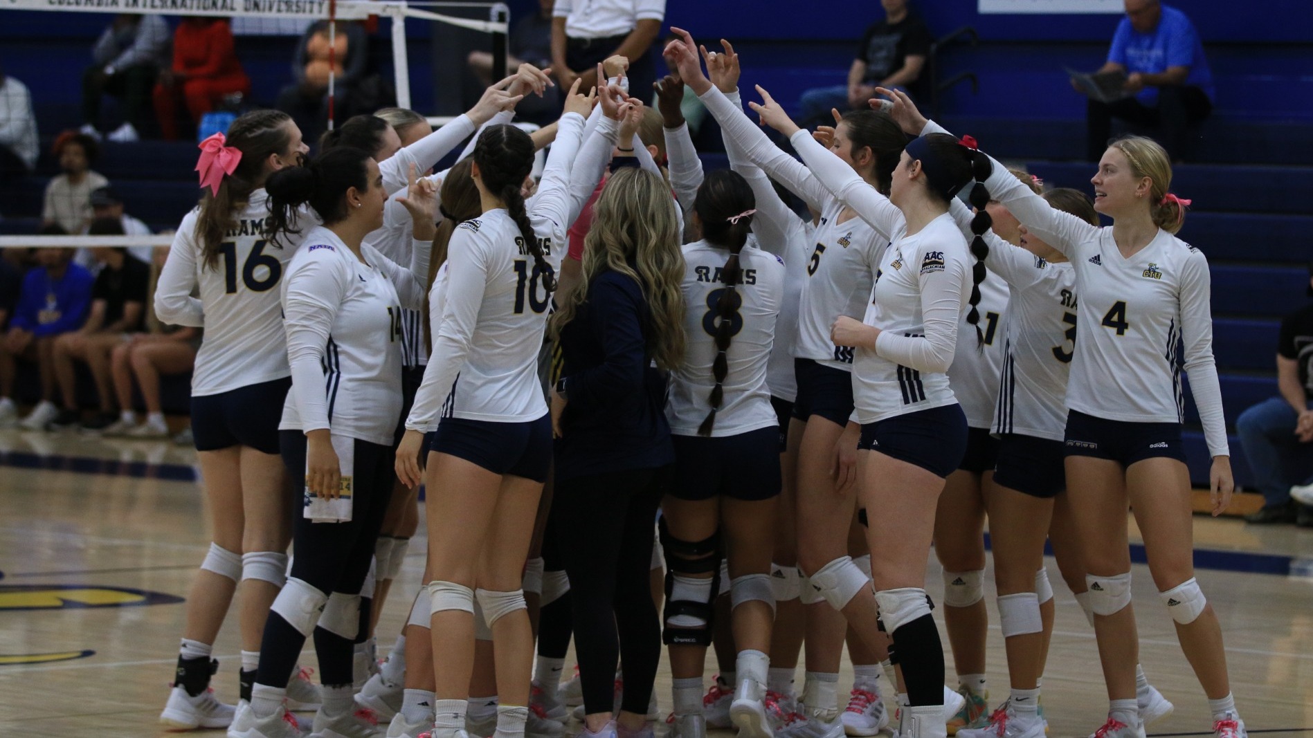 CIU volleyball team huddles after a game 