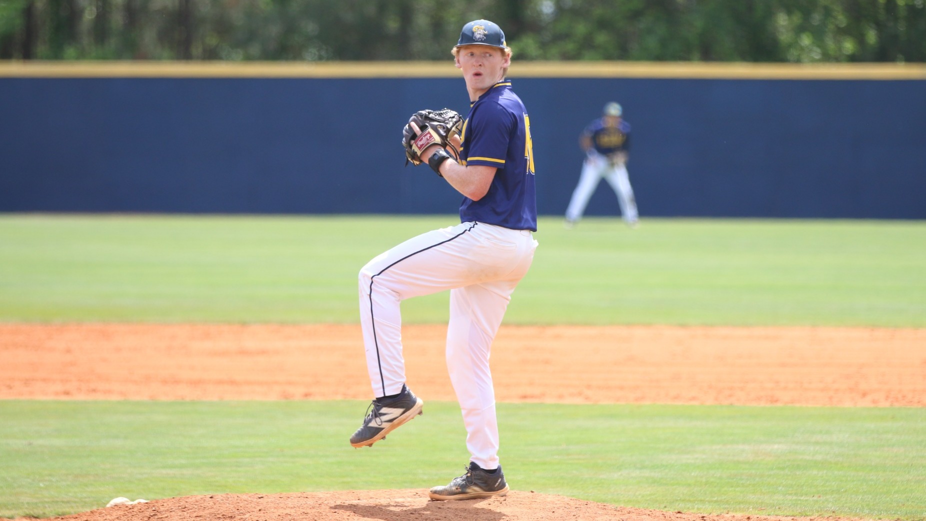Michael Meilinger stands on the mound with his front leg raised, preparing to deliver a pitch