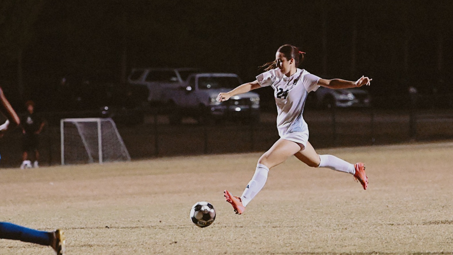 Female soccer player taking a shot. 