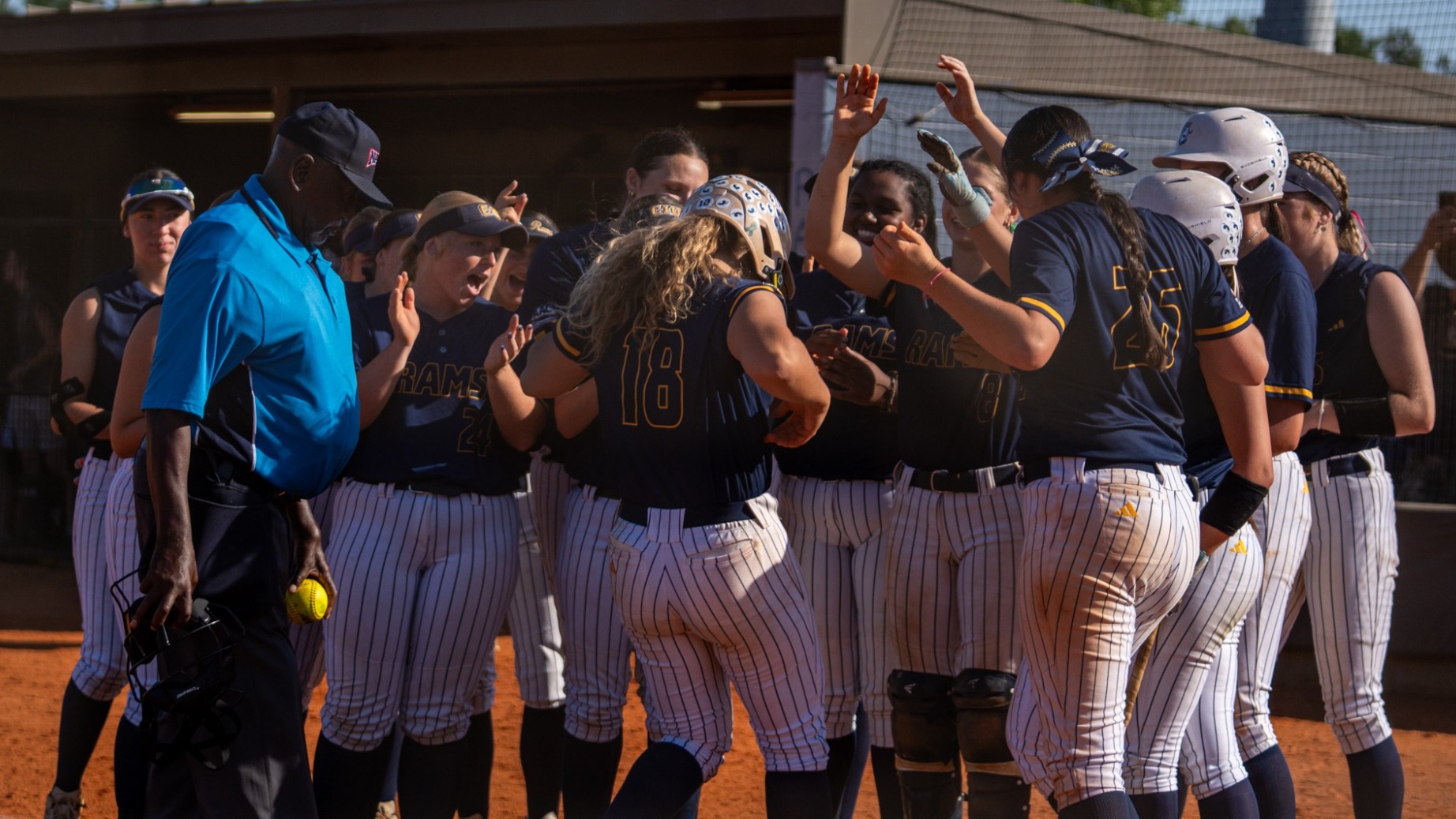The softball team celebrates with Caydon Thompson after a homerun 