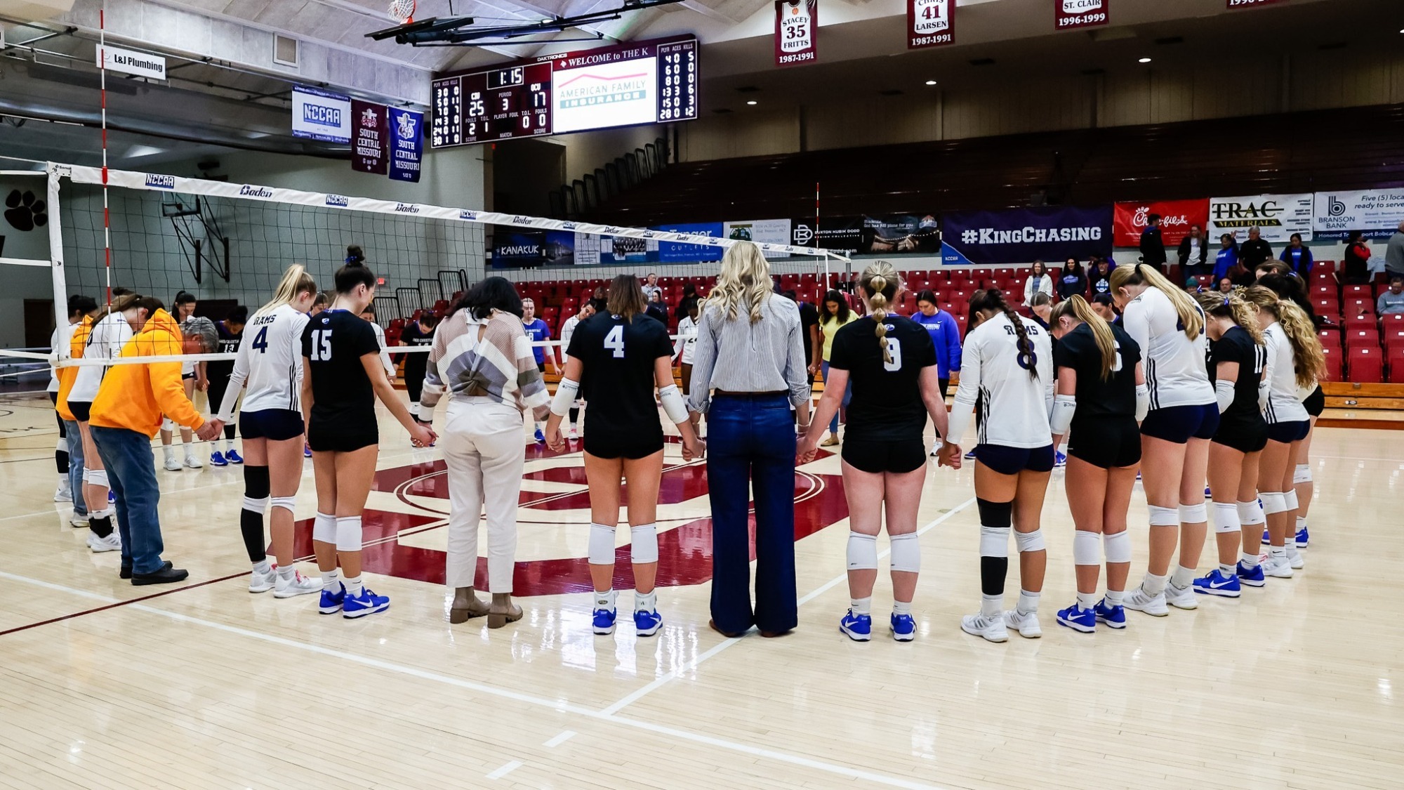 CIU volleyball prays with their opponent after a game 