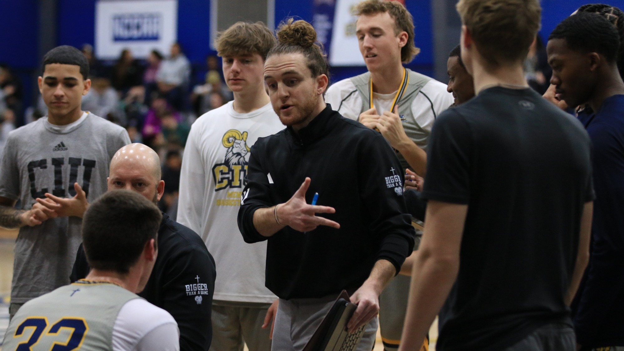 Cory Inman talks to CIU men's basketball in a huddle 