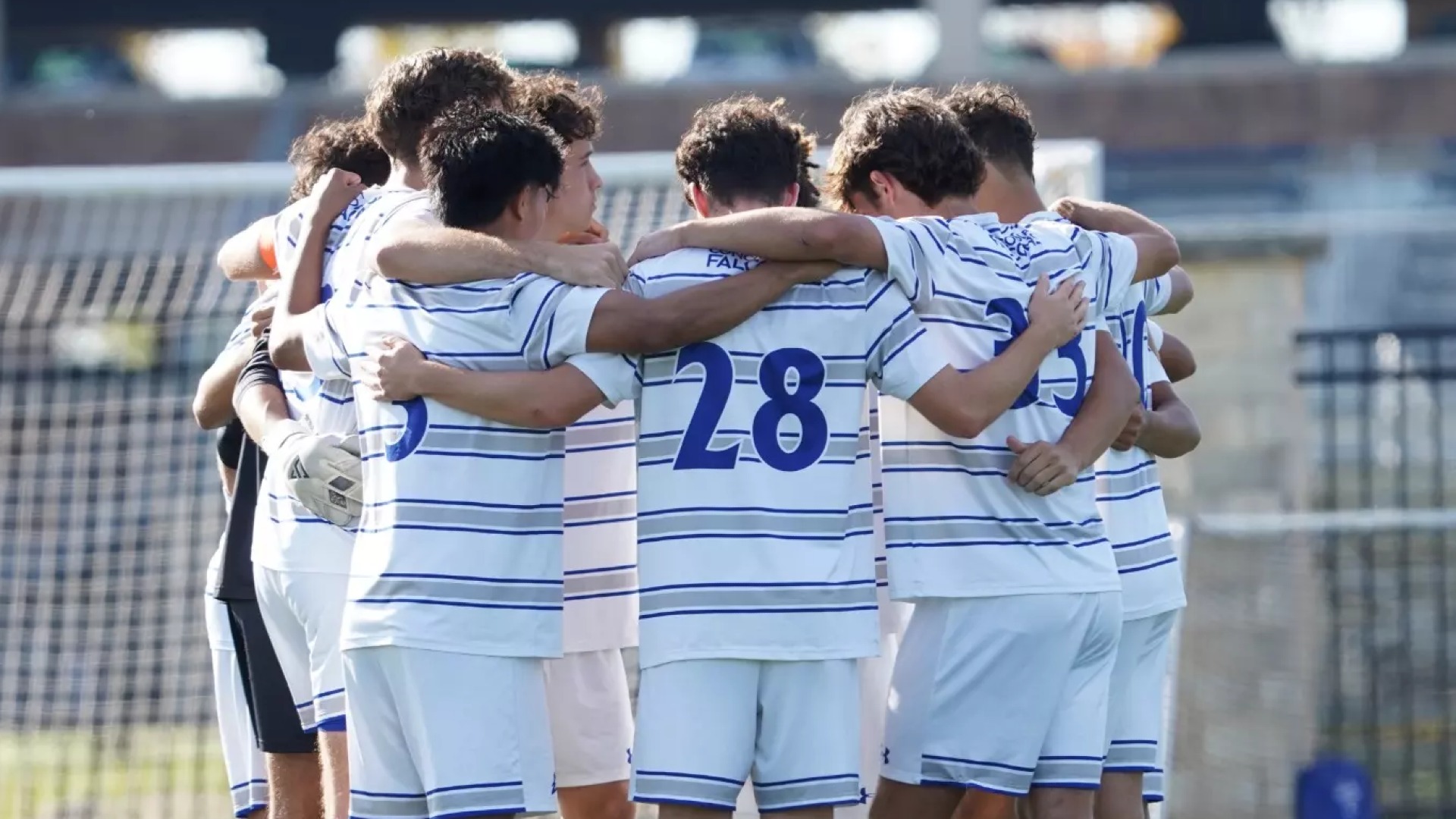 The men's soccer team huddled together.