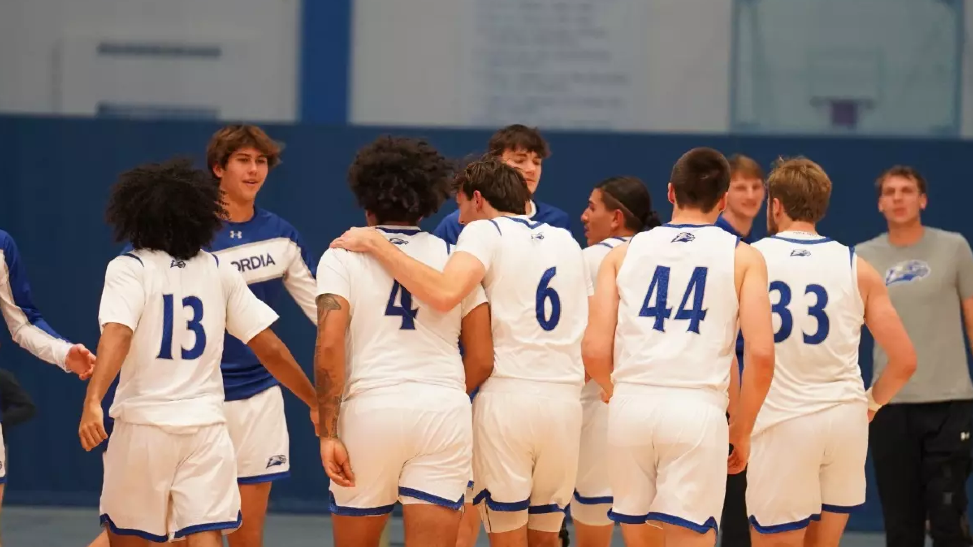 The CUW men's basketball team walking to the bench.