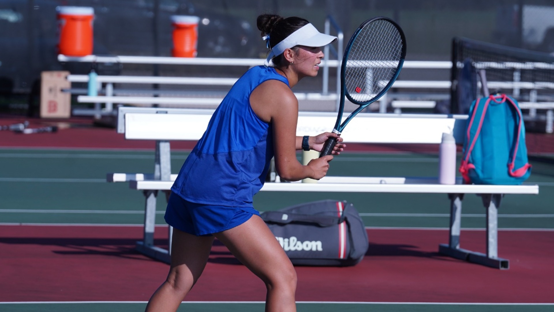 A CUW women's tennis player getting ready for a rally at the net.