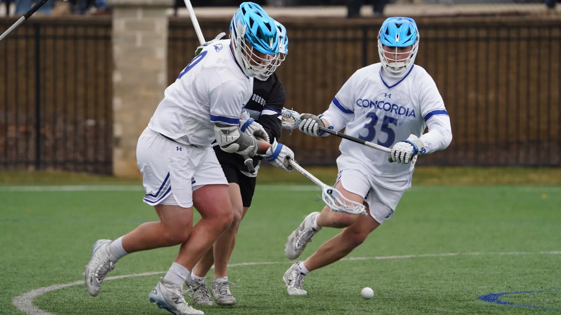 Two CUW men's lacrosse players going for the ball.