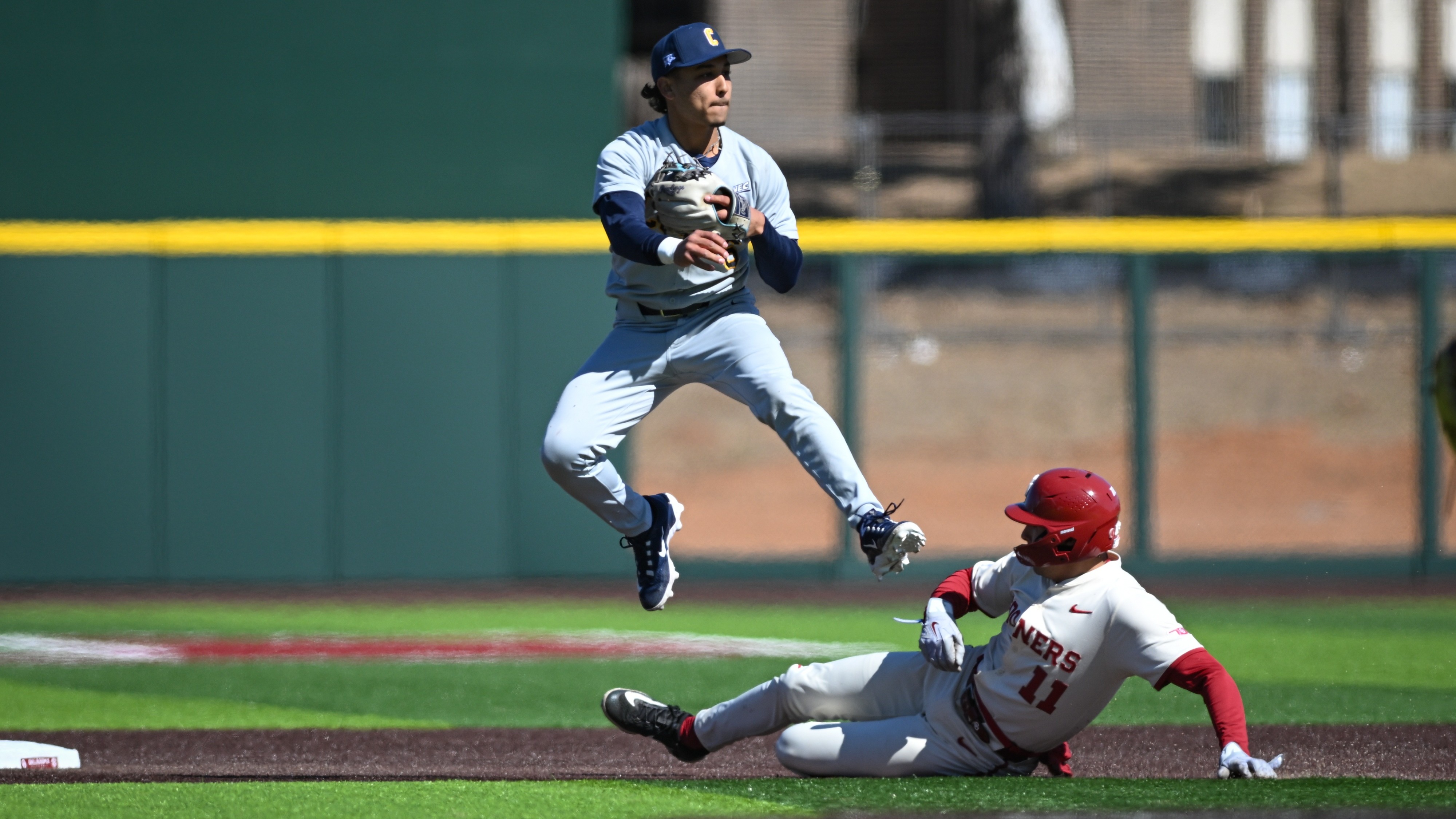 Emilio Feliciano leaps over baserunner after throwing to first at #19 Oklahoma