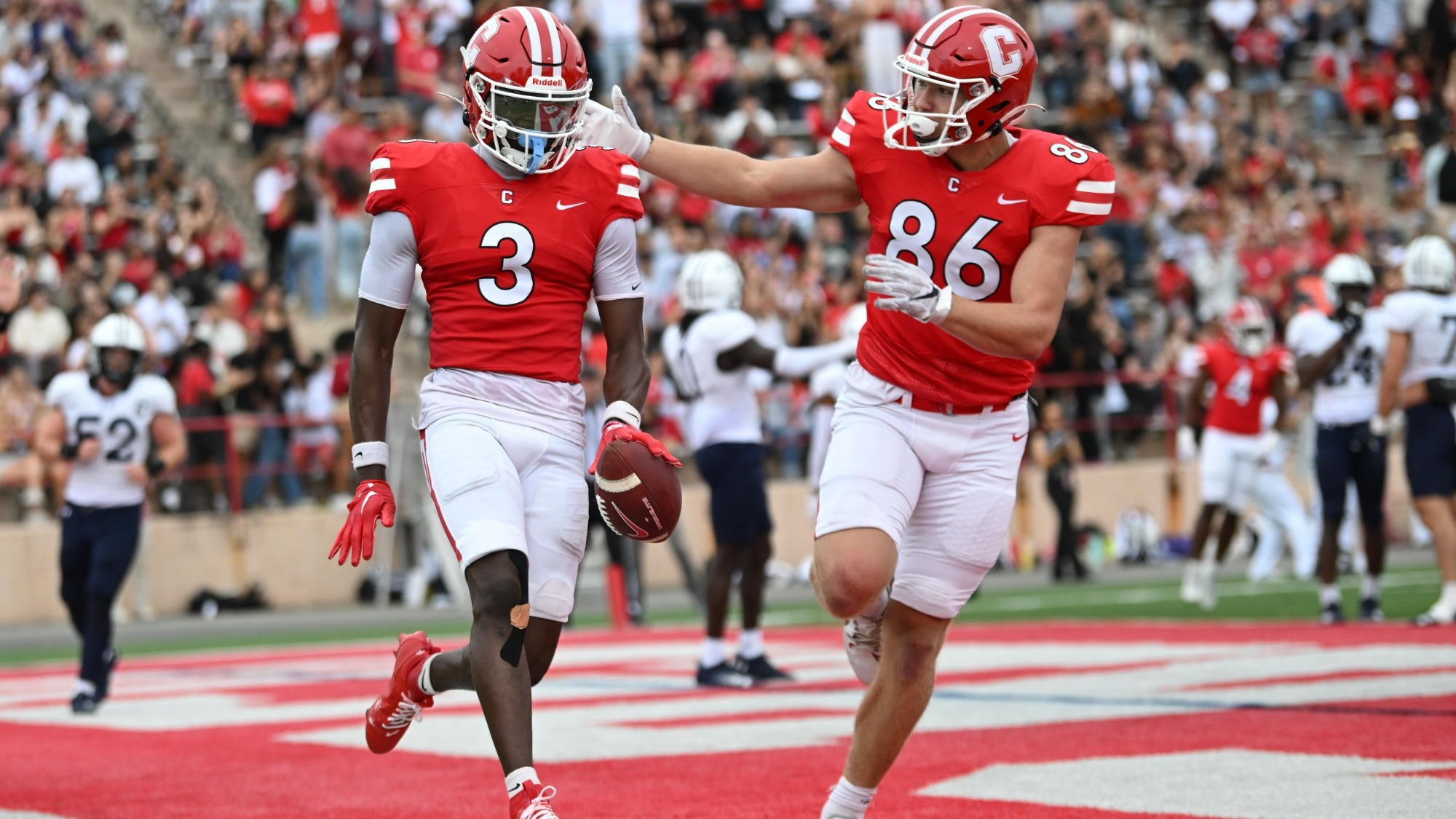 Sam Musungu and Ryder Kurtz celebrate a touchdown.