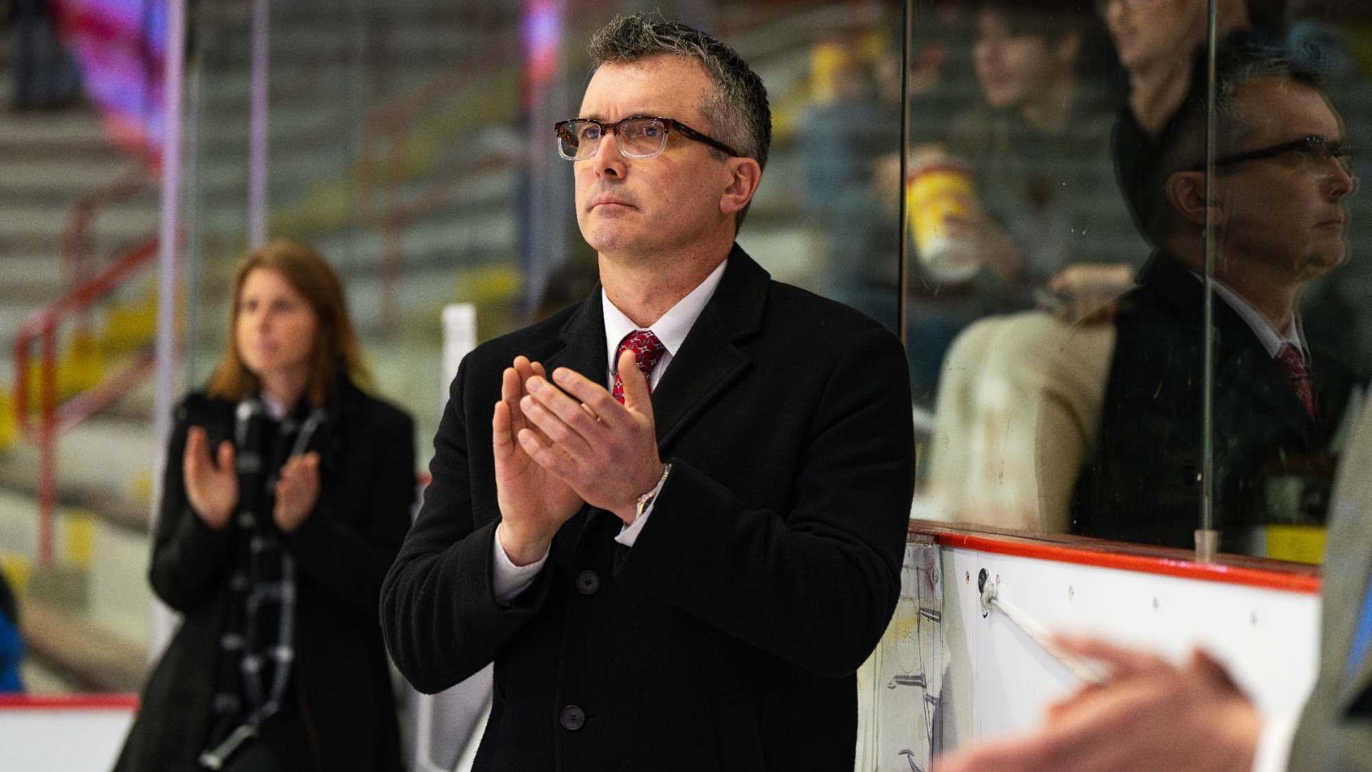Doug Derraugh applauds on the bench at Lynah Rink.