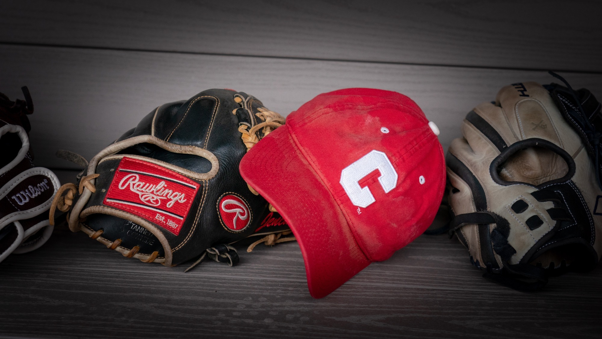 Misc shot of Cornell hat and gloves on the dugout bench.