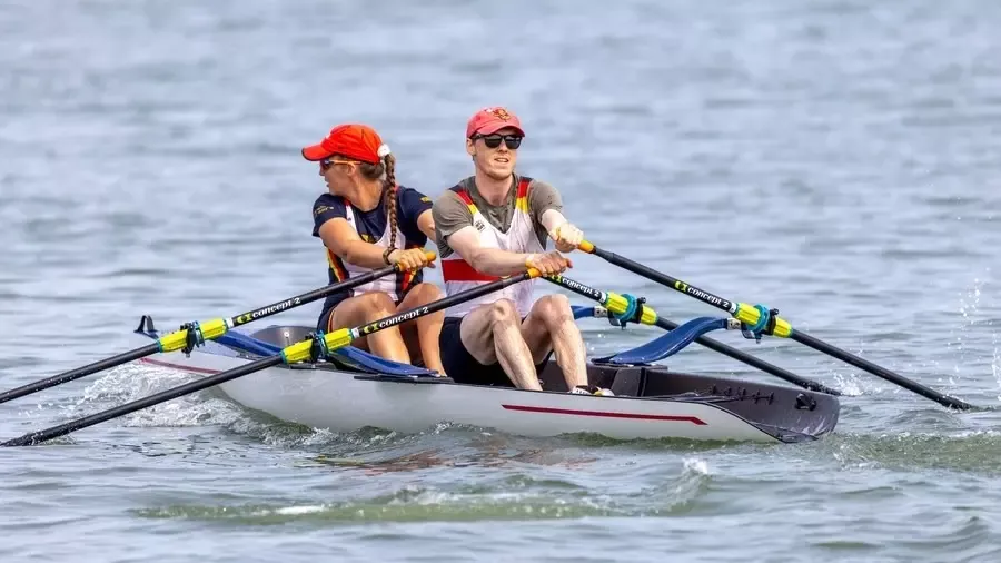 An action photo of Cornell rowing alums Solveig Imsdahl '13 and Nick Potter '21 rowing together.