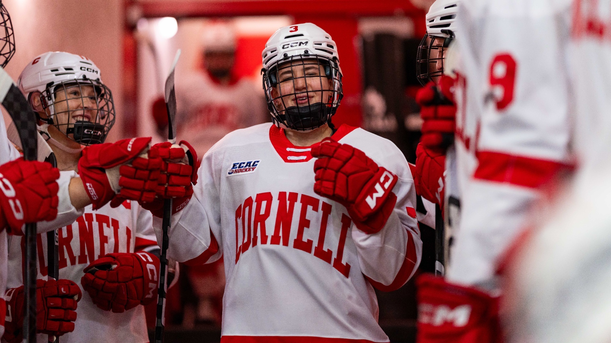 Piper Grober fist bumps teammates as she walks through the tunnel at Lynah Rink.
