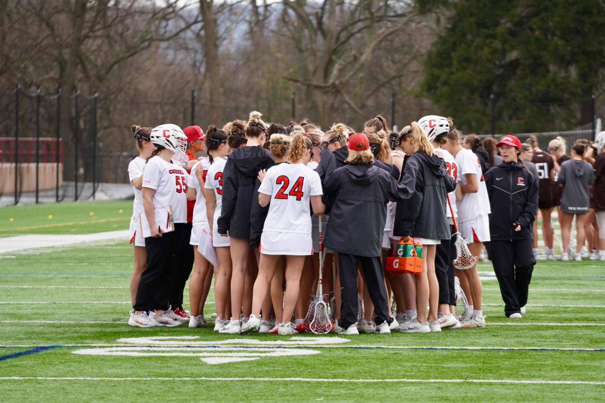 Big Red Women's Lacrosse huddle on Schoellkopf Field during game 