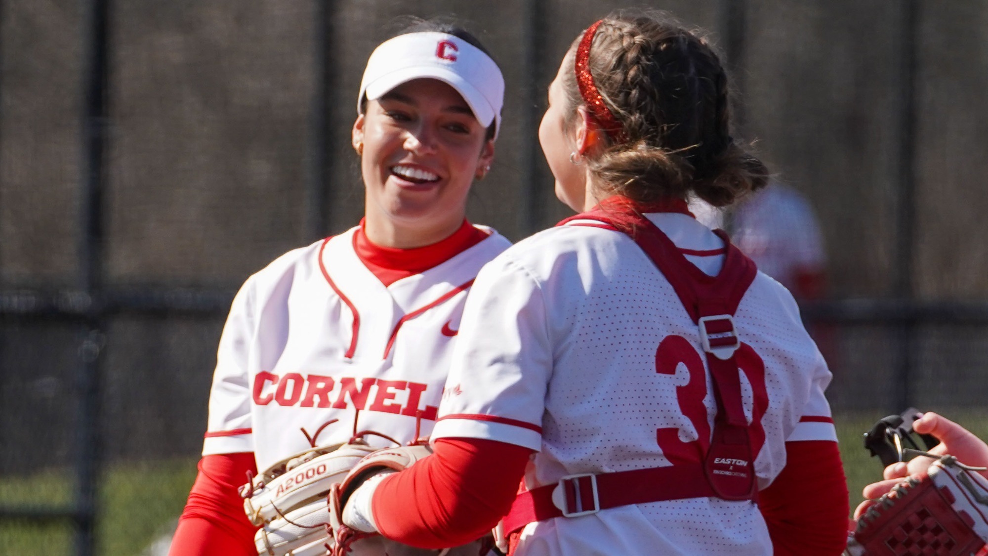 Cornell softball players chatting at Niemand-Robison Field.