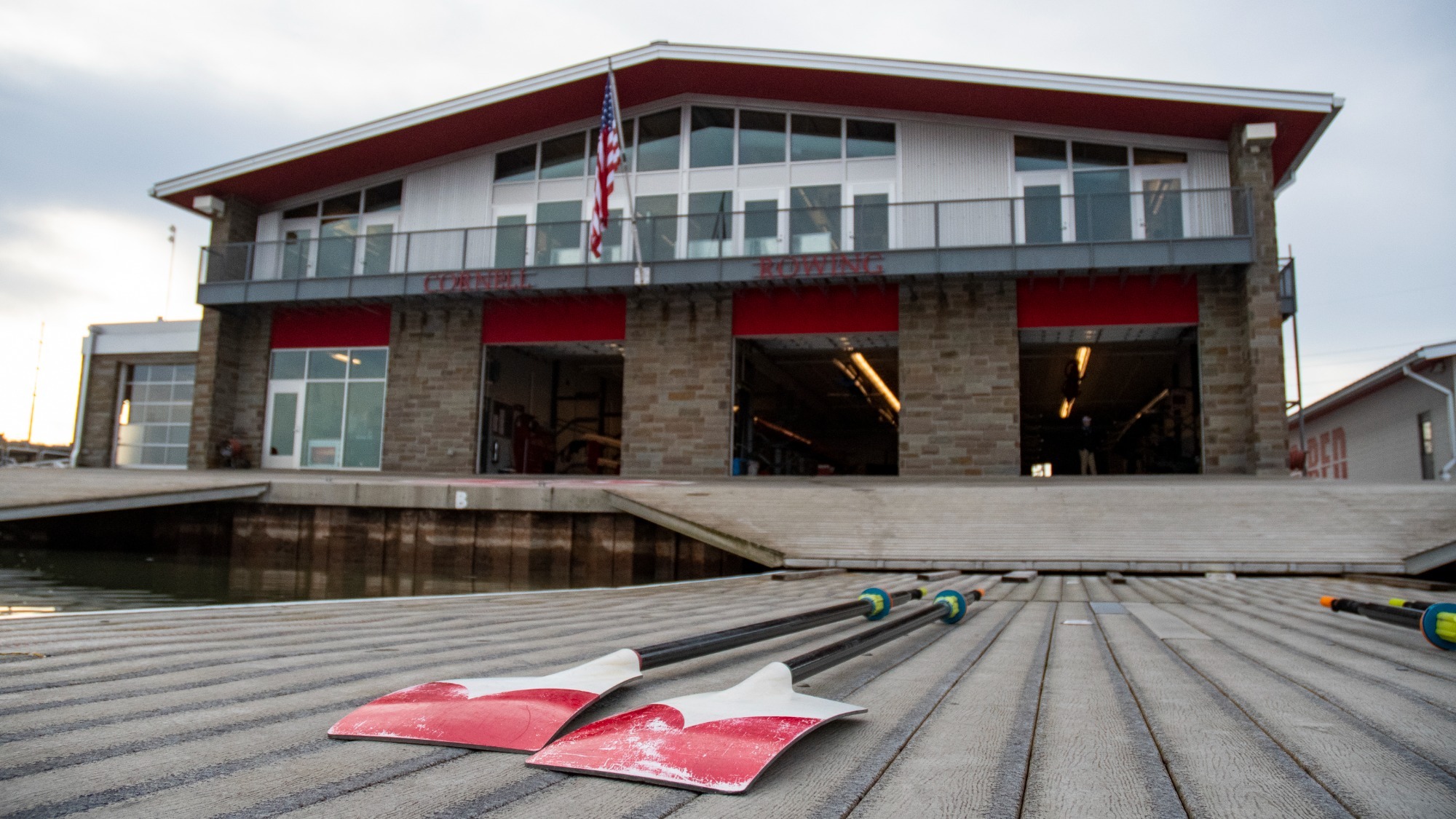 Cornell rowing boat house with paddles laying on the dock.