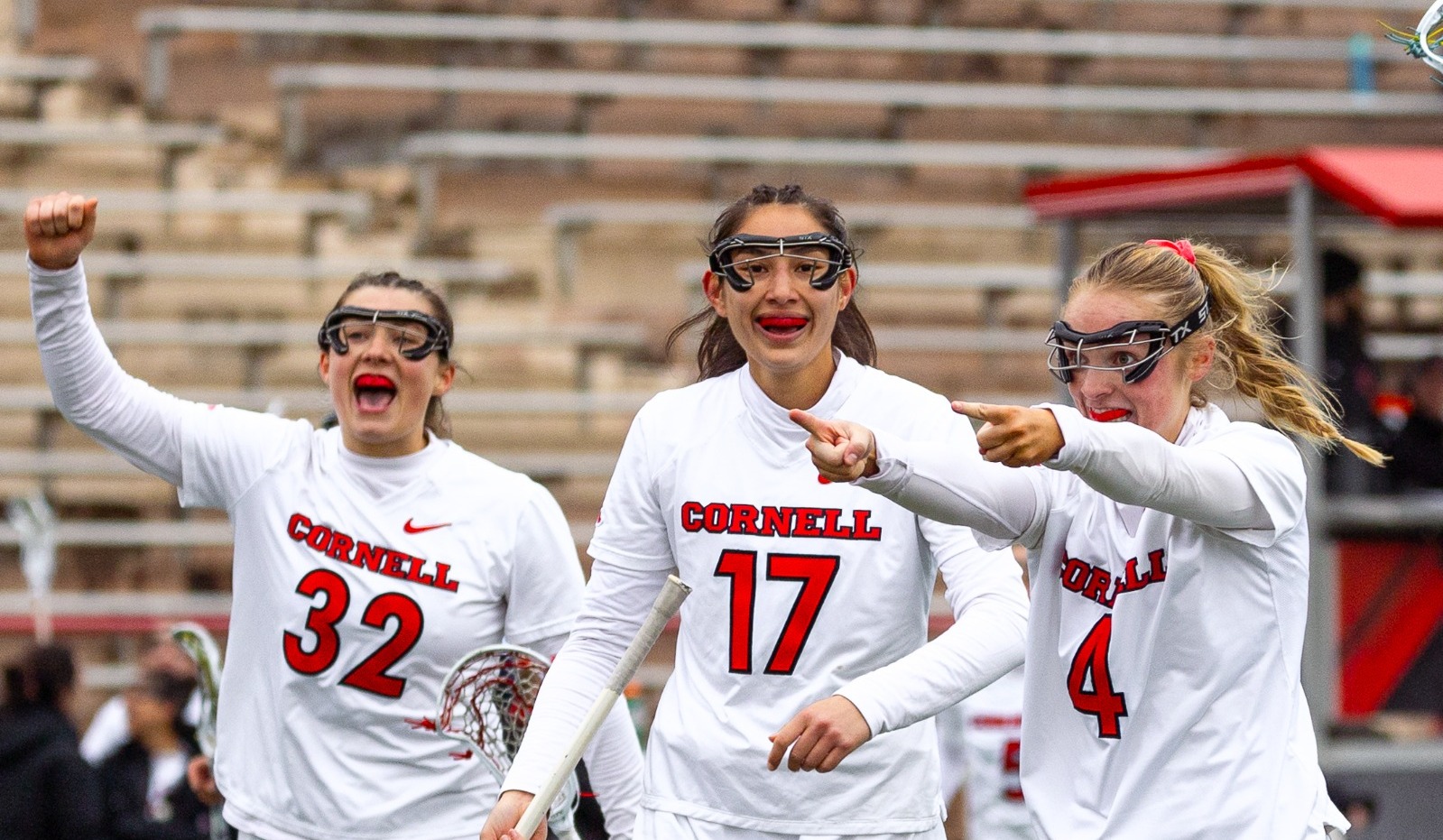 Ellie Bergin (32), Cameron Traveis (17) and Ella Wilmot (4) celebrate after a goal vs. Columbia on Schoellkopf Field