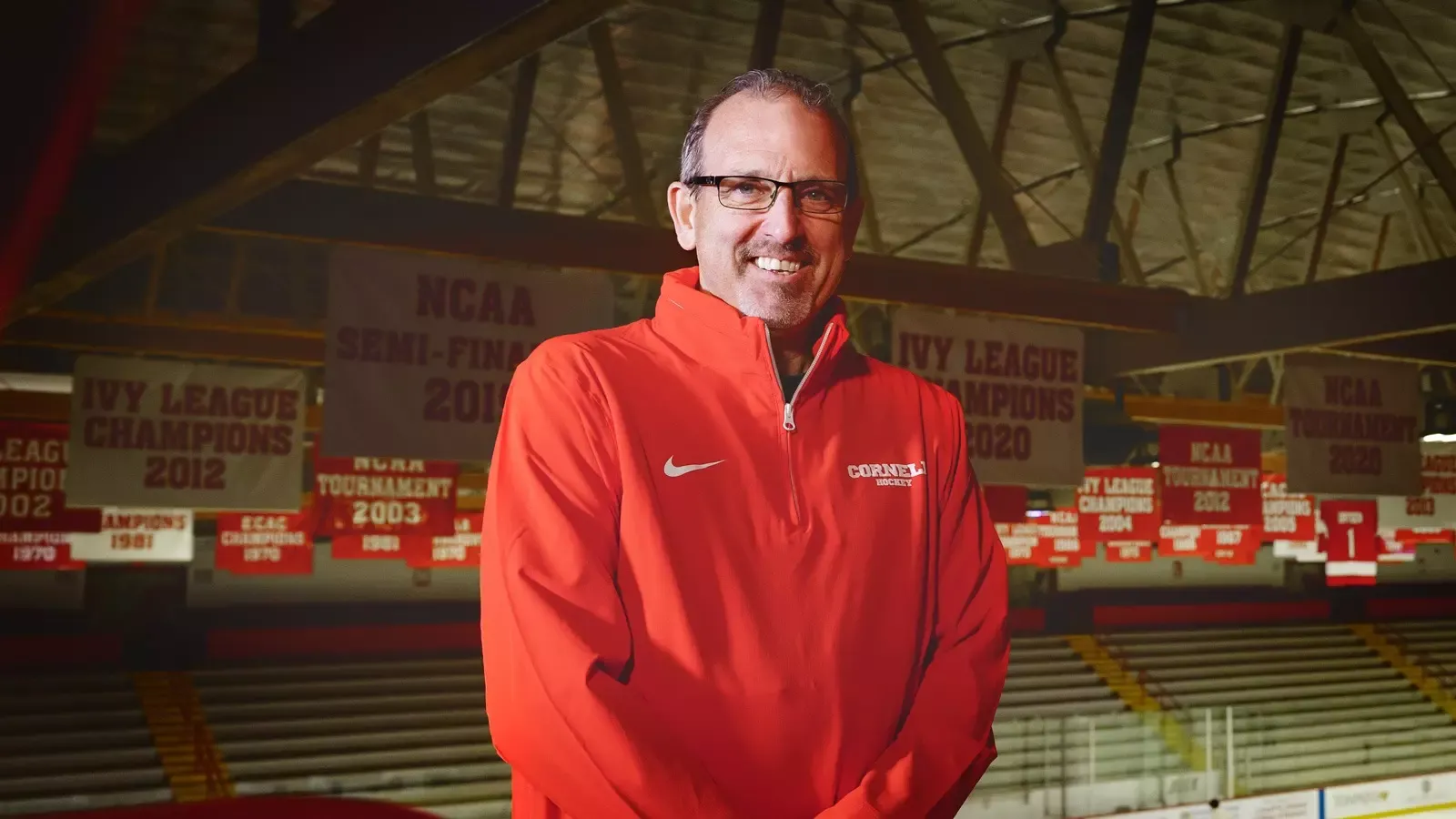 Cornell men's hockey head coach Casey Jones '90 poses for a portrait photo inside Lynah Rink.