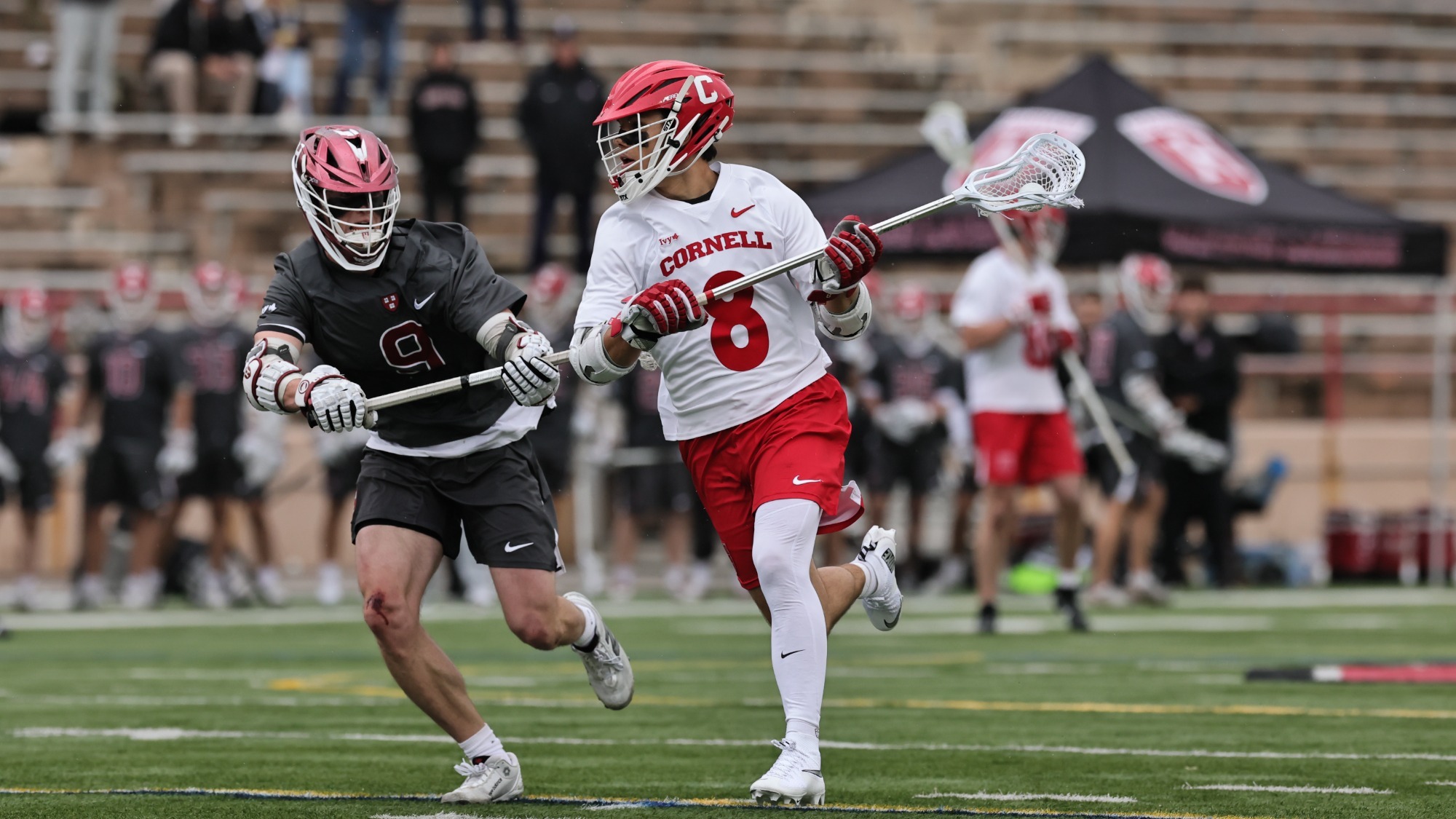 Cornell men's lacrosse attackman Luke Robinson (8) drives past a Harvard defender during the Big Red's Ivy League semifinal win over the Crimson on May 1, 2026, at Schoellkopf Field in Ithaca, N.Y.