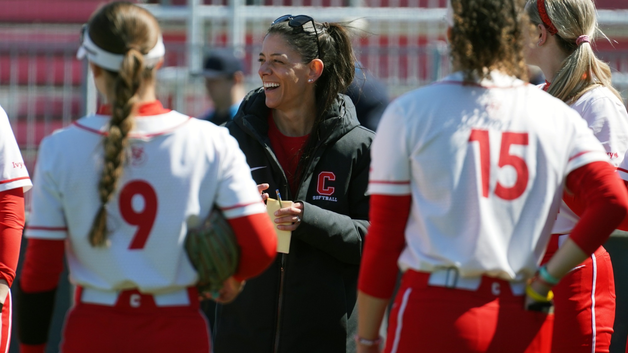 Cornel lsoftball coach Tara Smith laughs with members of the team between games in a doubleheader against Colgate on April 8, 2026 at Niemand-Robison Field in Ithaca, N.Y.