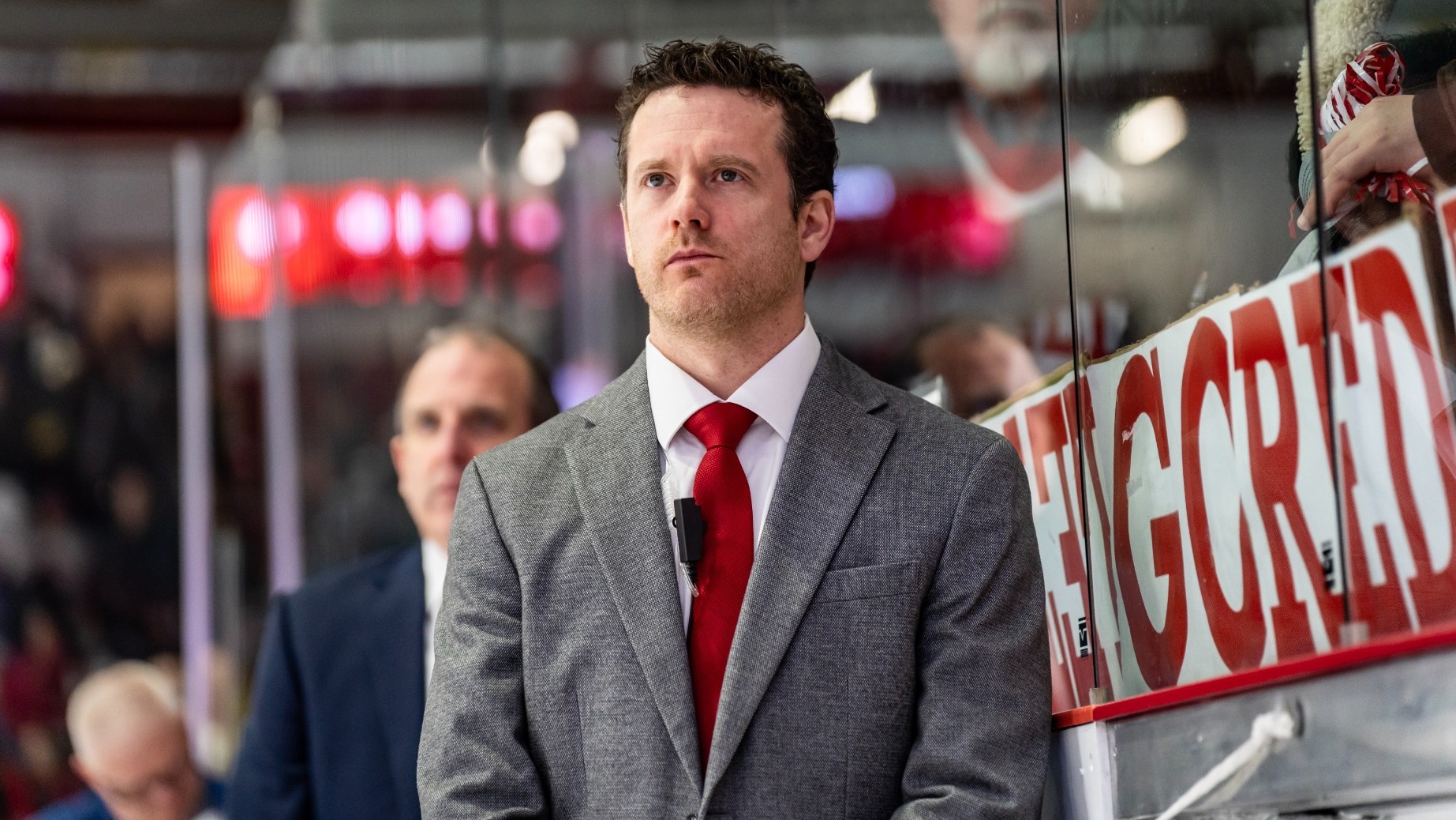 Cornell men's hockey associate head coach Sean Flanagan stands behind the bench during the 2025-26 season.