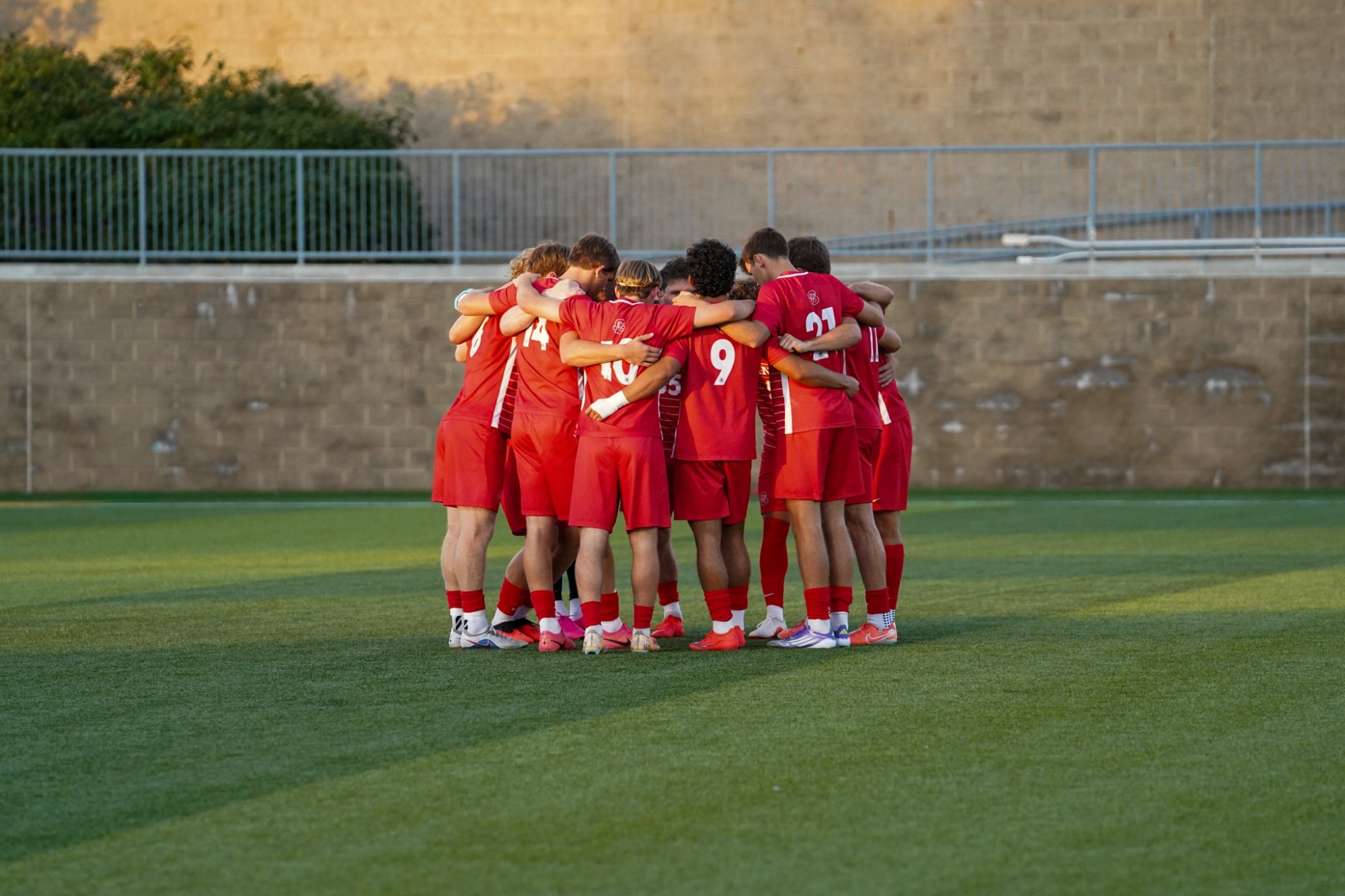 Men's Soccer in a huddle before kick off