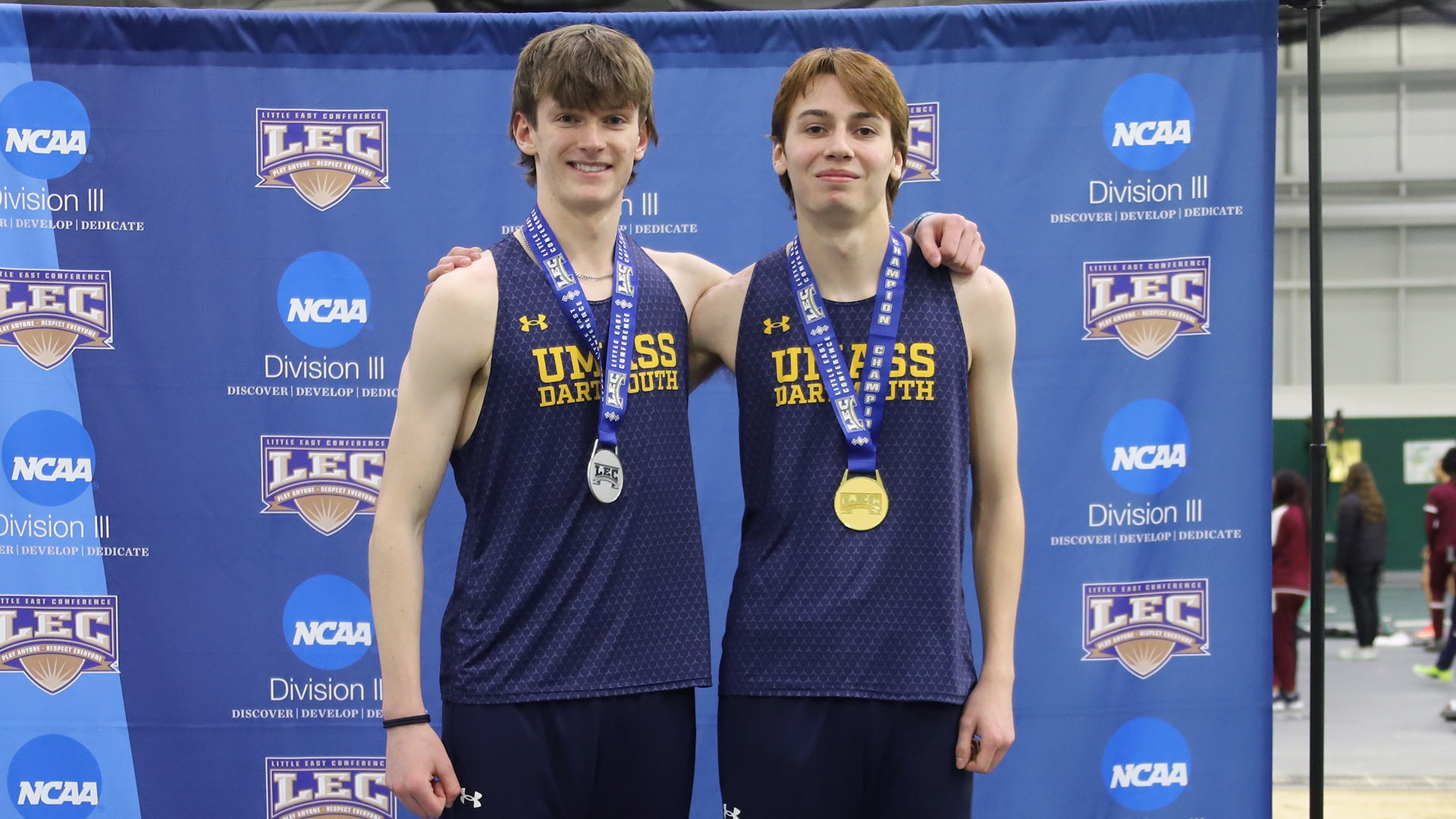 Ewan McLeod and Sean Patrone pose on the podium after earning silver and gold in the high jump at 2026 Little East Indoor Track & Field Championships