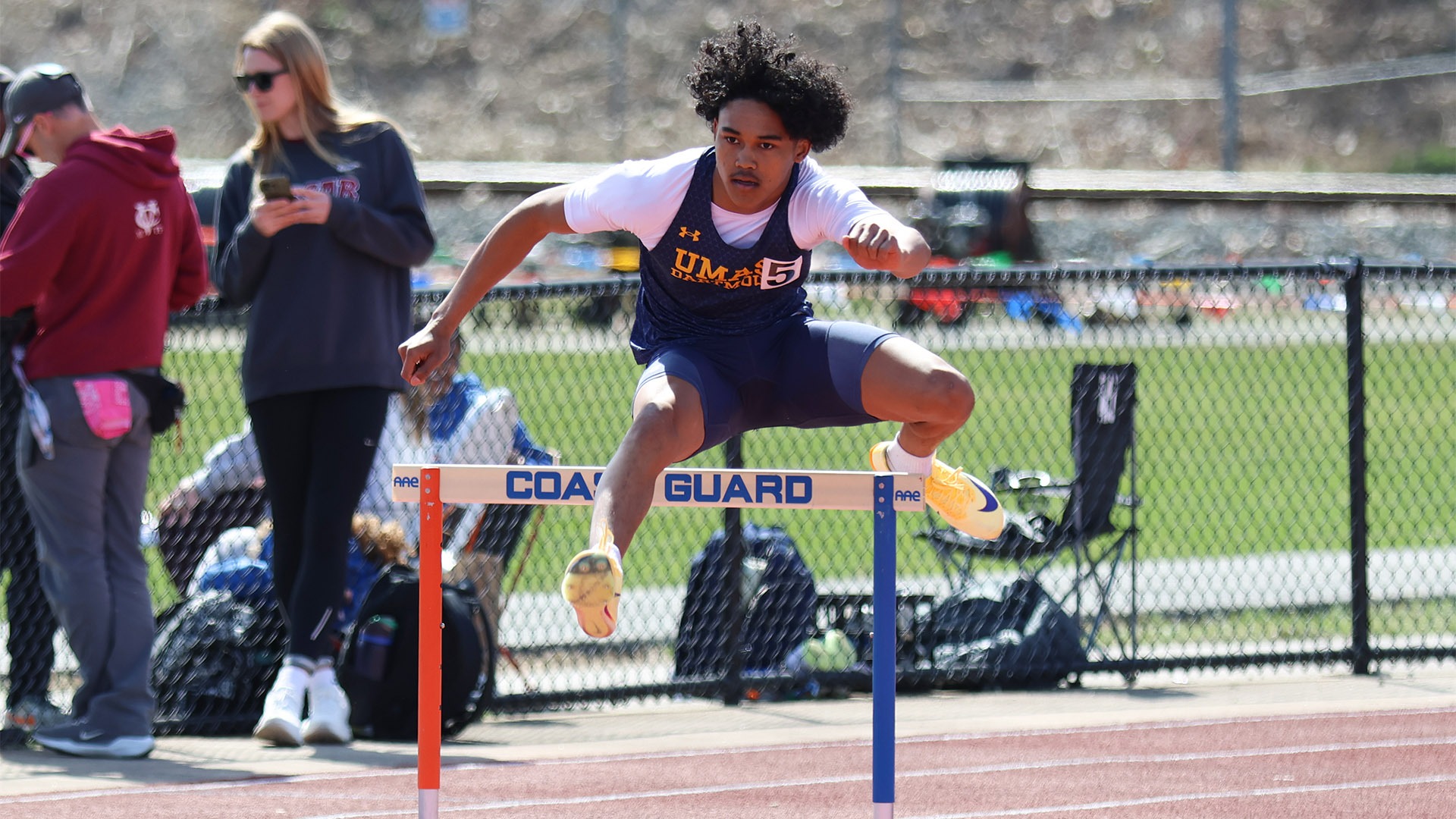 Rookie Jayden Francois jumps over a hurdle in a 400-meter hurdles race at Coast Guard
