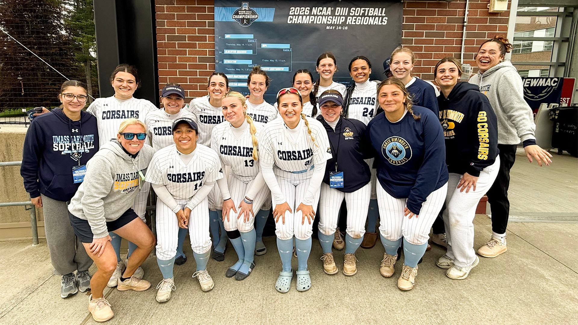 Softball poses in front of the NCAA Banner after advancing past Stockton, 12-2